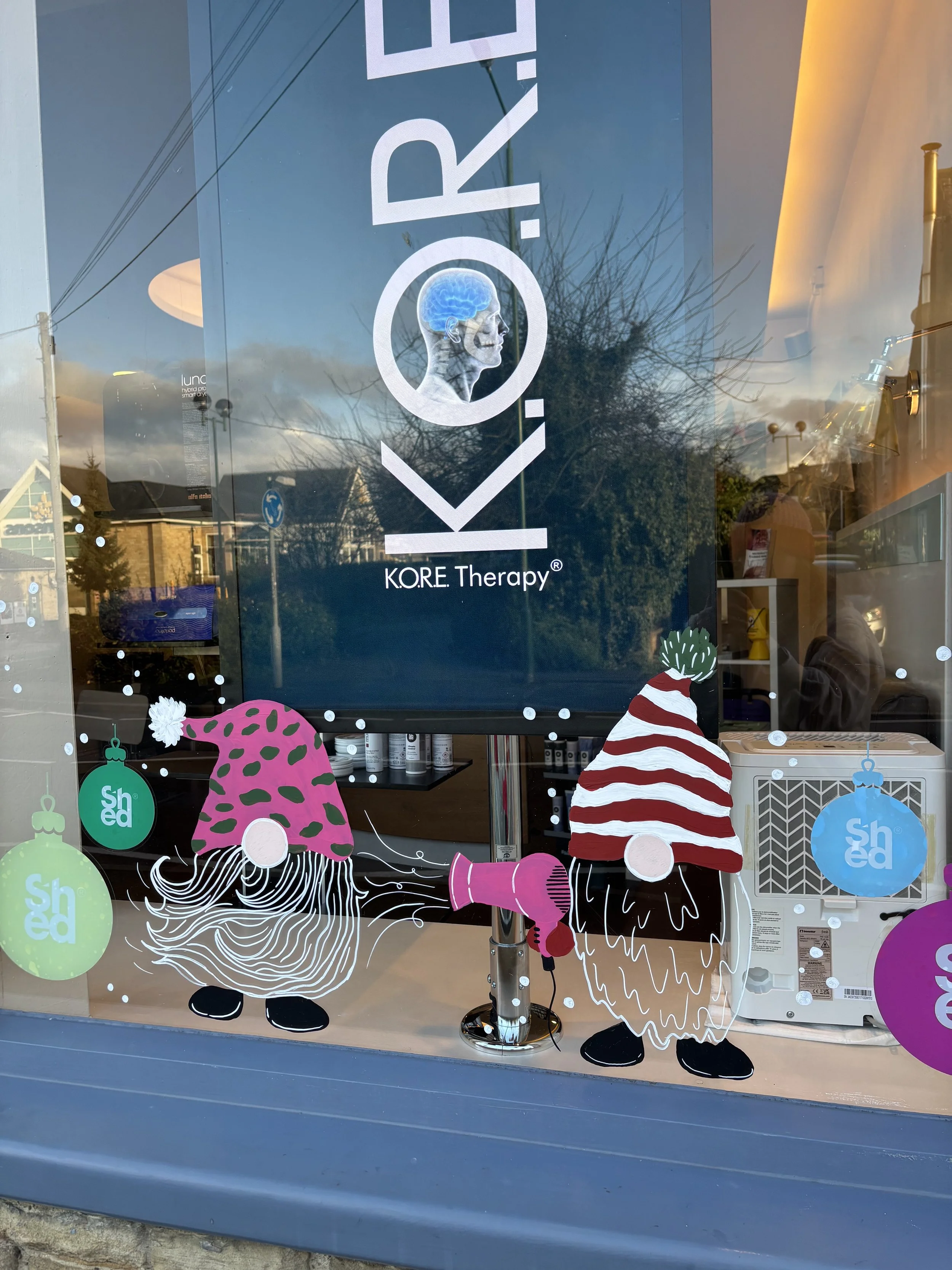 Hand painted Christmas window in bright fun colours including gonks and hair salon theme. Painted windows, window painting. 