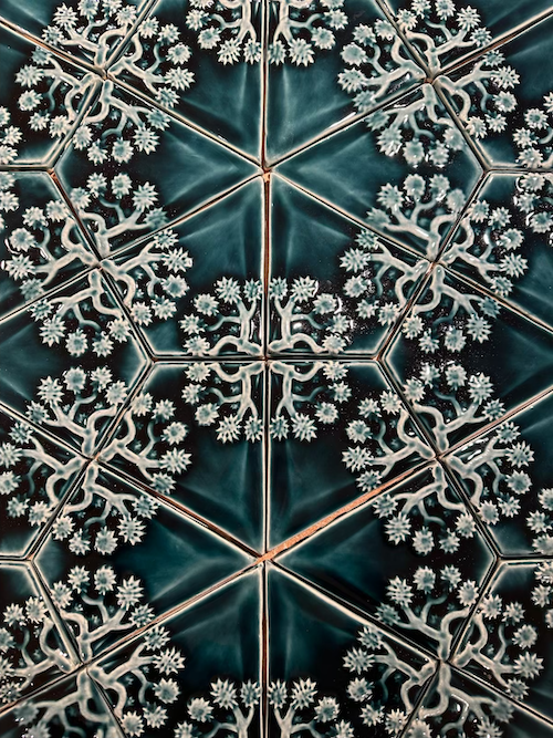 Close-up of decorative tiles with snowflake patterns and intricate designs in a geometric arrangement.