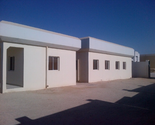 A white building with small windows under a clear blue sky.