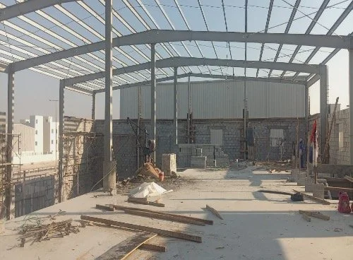 Construction site of a building with a steel frame and unfinished concrete floor