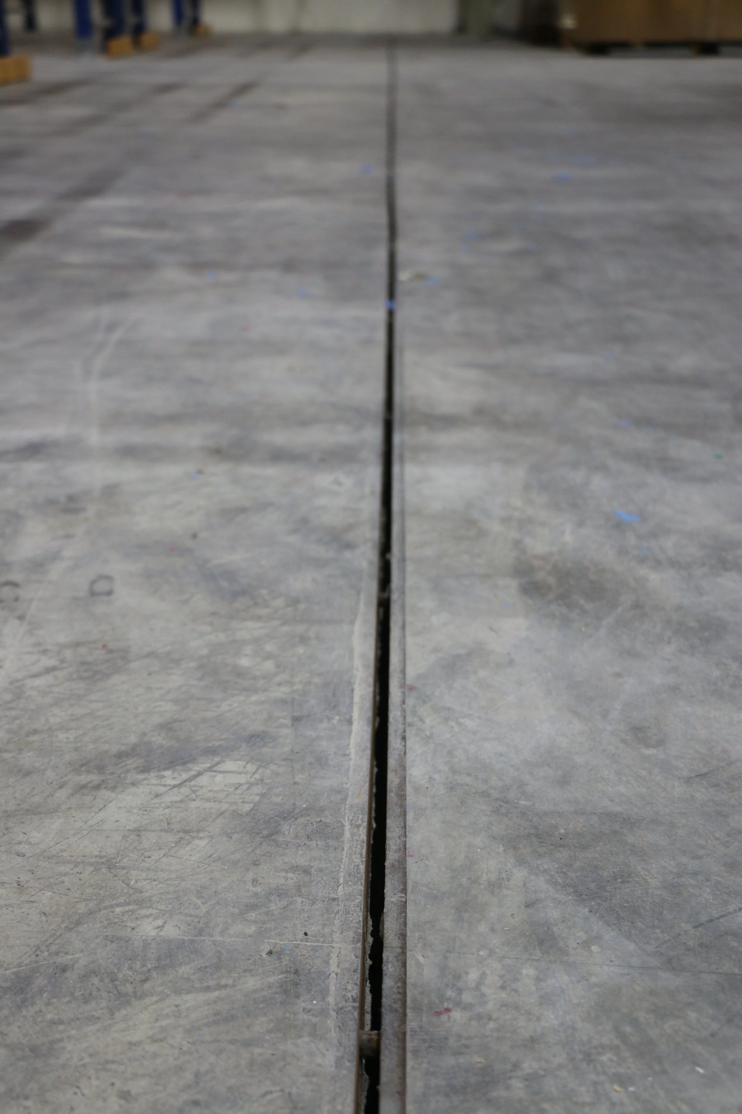 Close-up of concrete floor with a movement joint running down the center, revealing a narrow gap.