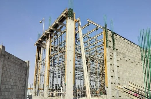 Construction site with steel framework and concrete columns for a building under construction.