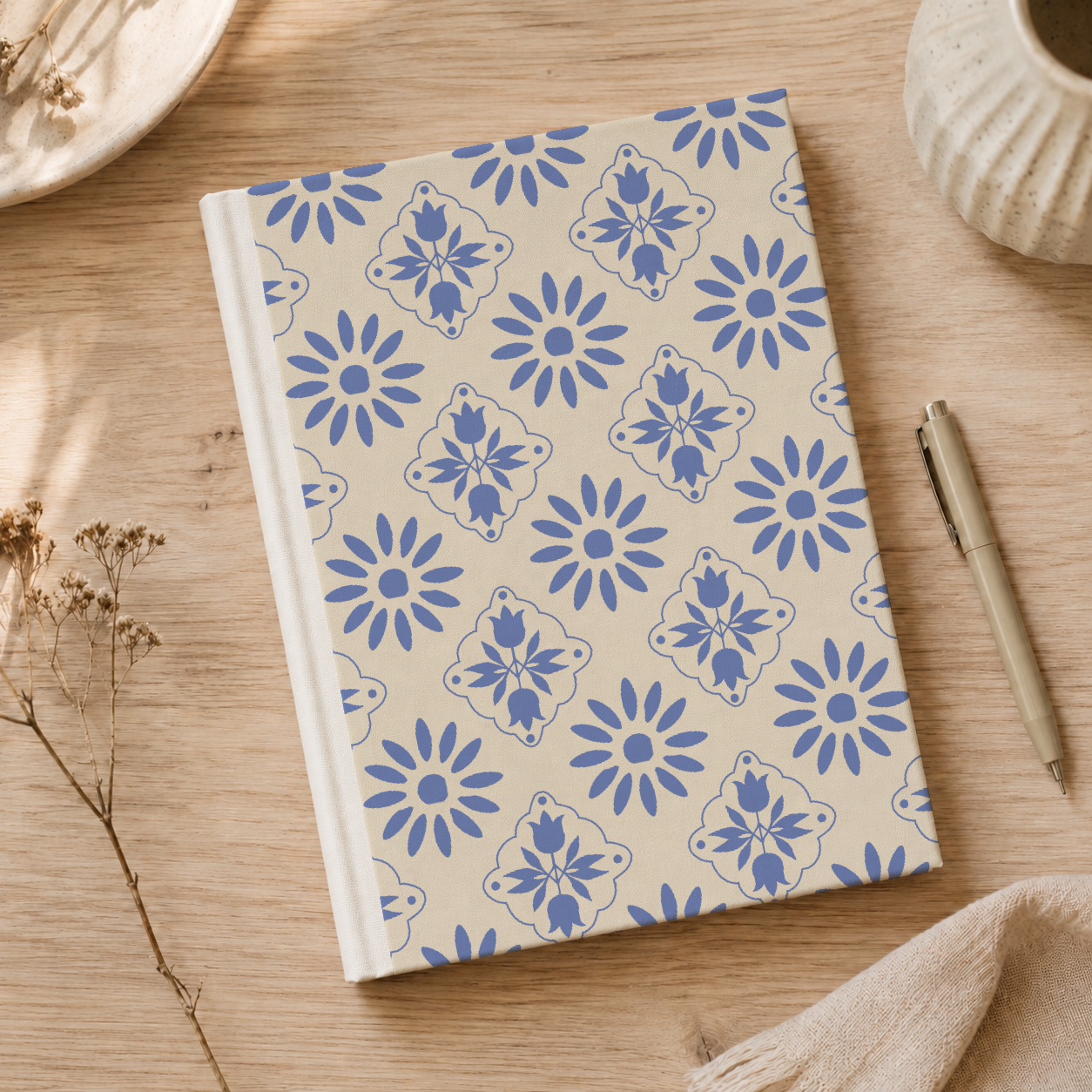 A notebook with a floral cover design, surrounded by tomatoes on a wooden surface.