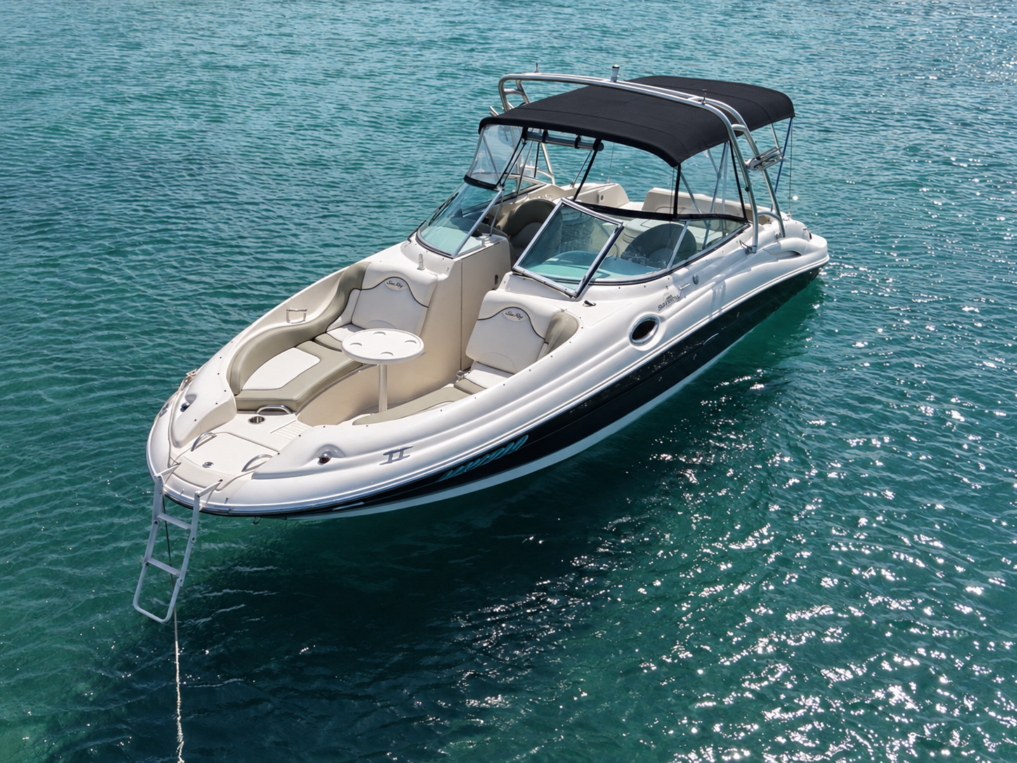 A white motorboat floating on clear blue water 