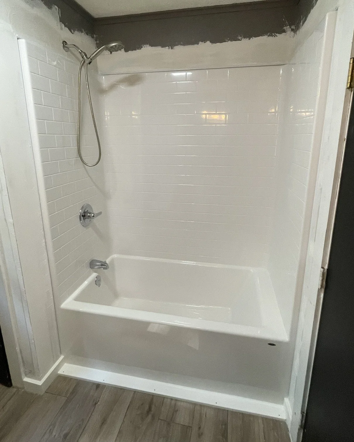 An old, painted-over tub and faulty plumbing were replaced by a new 1-piece shower unit and all new plumbing! Just waiting for the painter when this photo was taken.