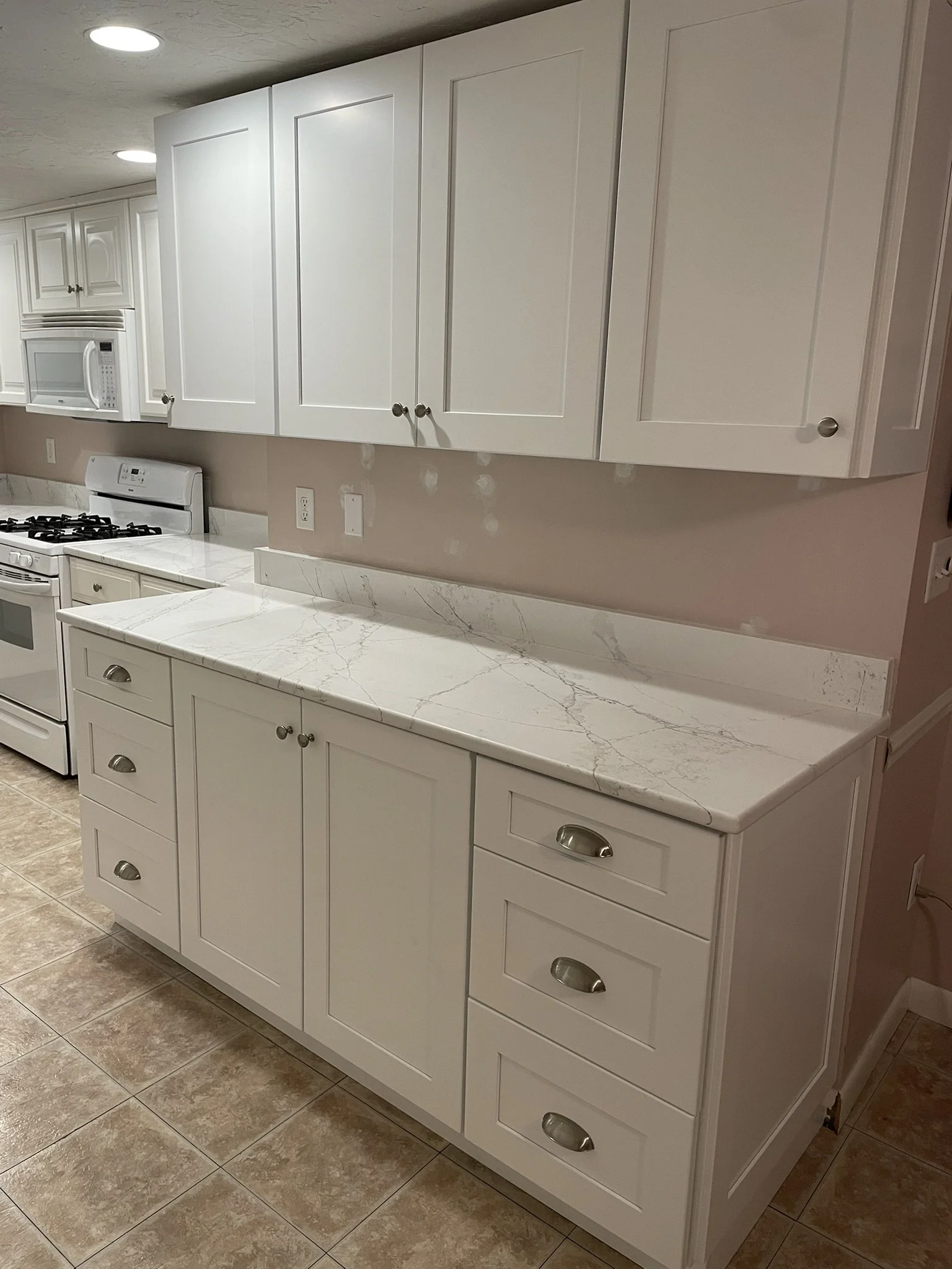 A large peninsula in an open kitchen/dining room provided some useful storage but mostly inhibited traffic flow in this busy, multi-generational summer home. By removing the peninsula and installing custom hardwood "pantry" cabinets (uppers and lower