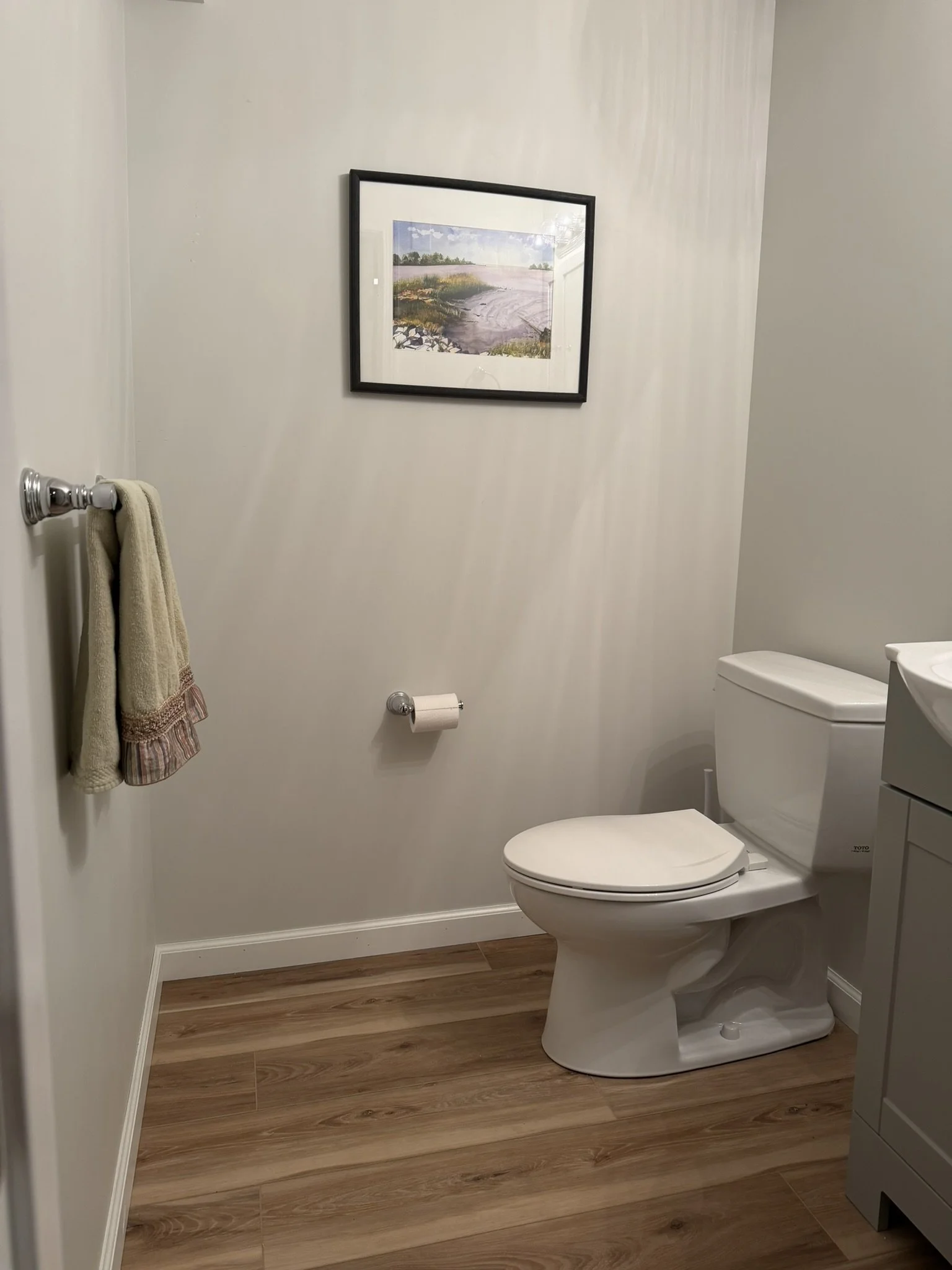 Fully utilizing this home's spacious, bright walk-out basement required the addition of a half-bathroom. A compact vanity maximizes space, while the extension of the luxury vinyl flooring from the adjacent Rec Room keeps cleaning and maintenance to a