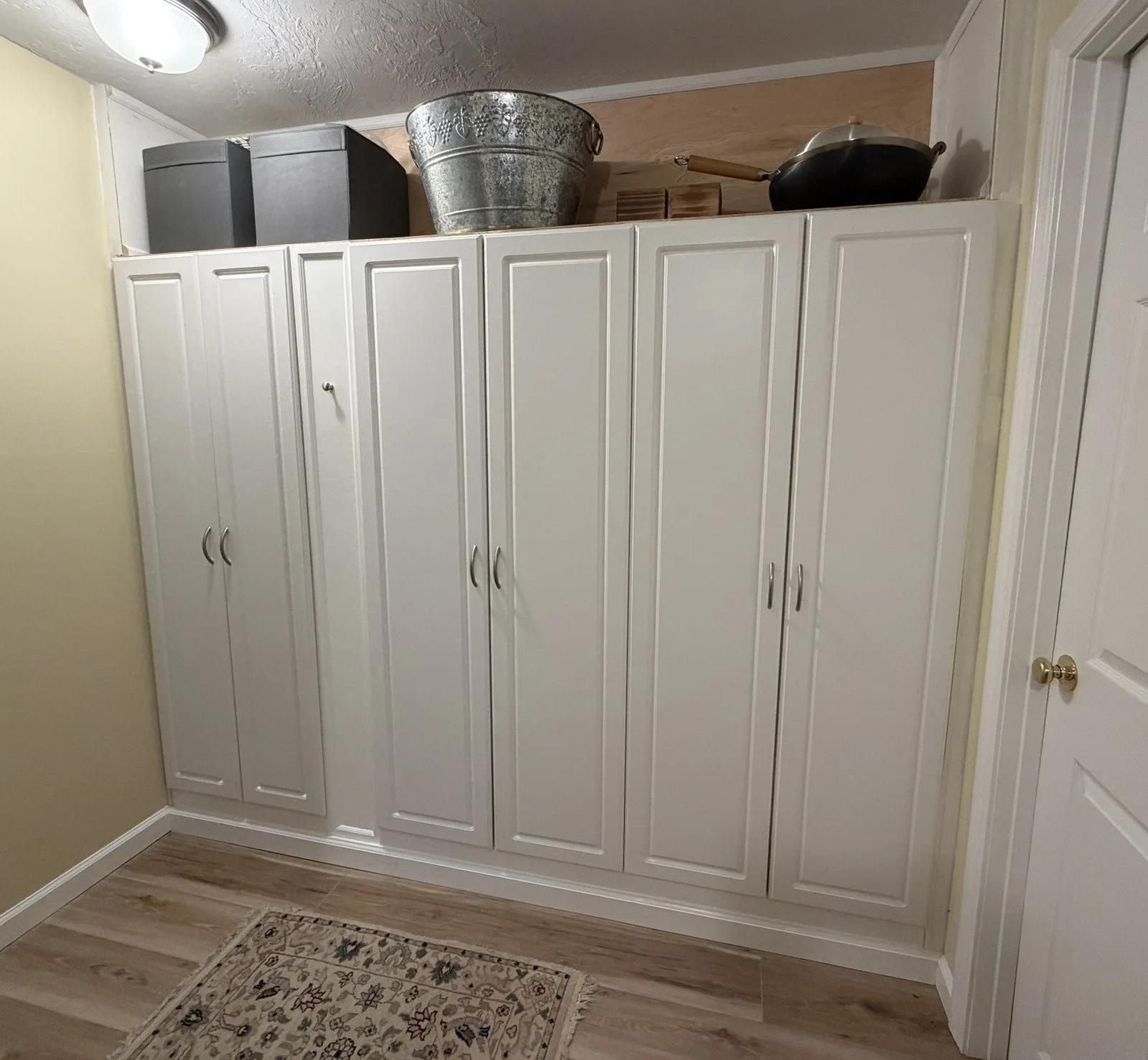 Built-In Pantry Cabinets: In this project, ready-made cabinets were fashioned into an attractive, spacious and permanent "pantry" in the dead space at the bottom of a stairwell. The unit shown measures 93" W x 72" H x 16" D for 58 cubic feet of space