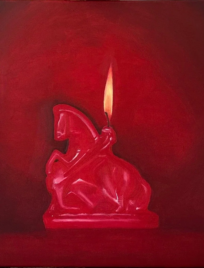 Red candle shaped like a firecracker with a lit flame on top.