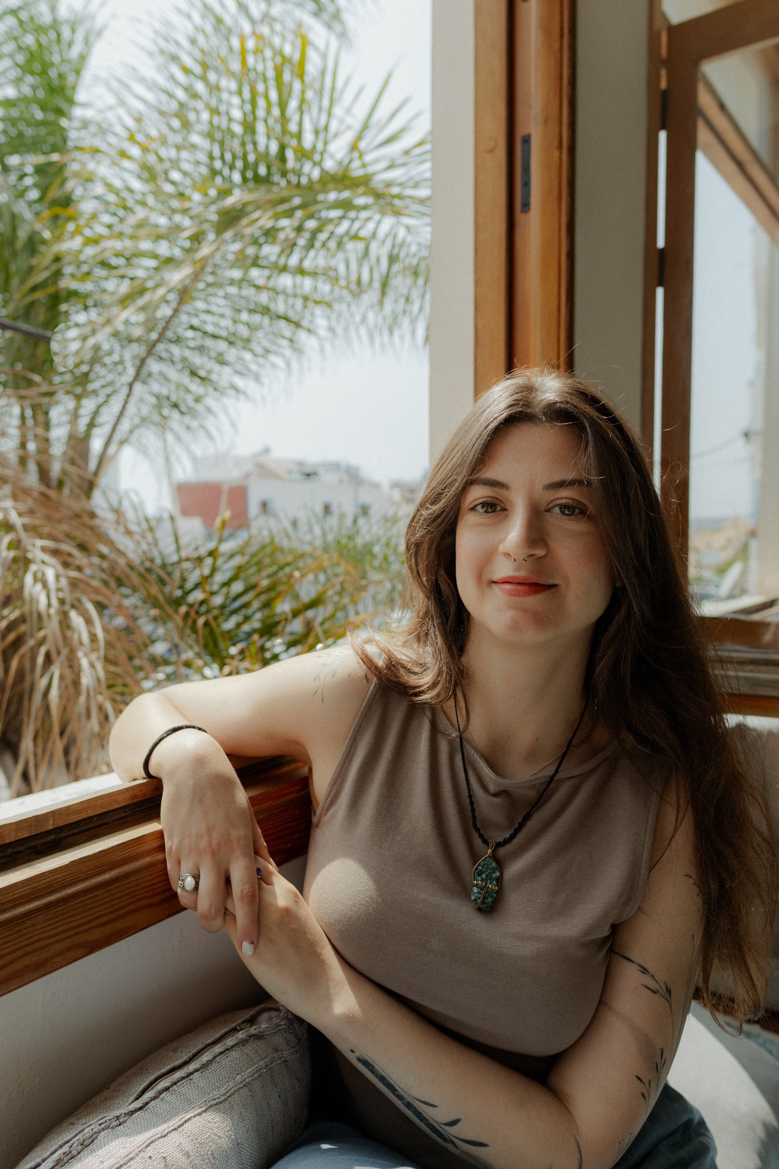 Maria Dimitreli, a therapist sitting next to a window