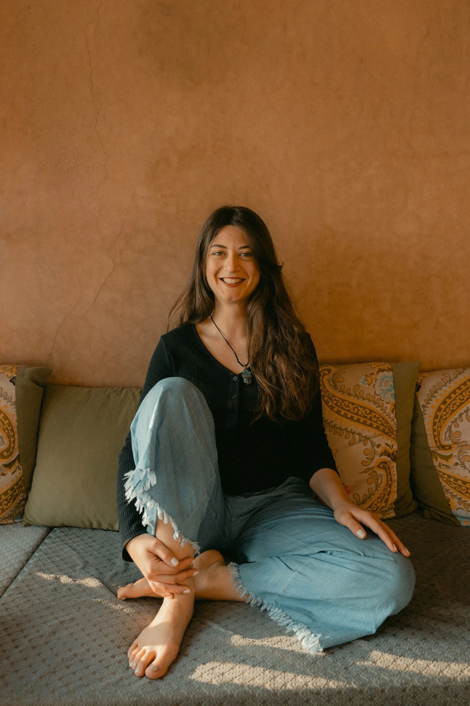 Maria dimitreli, a reiki practitioner and hypnotherapist sitting crossed legs and smiling