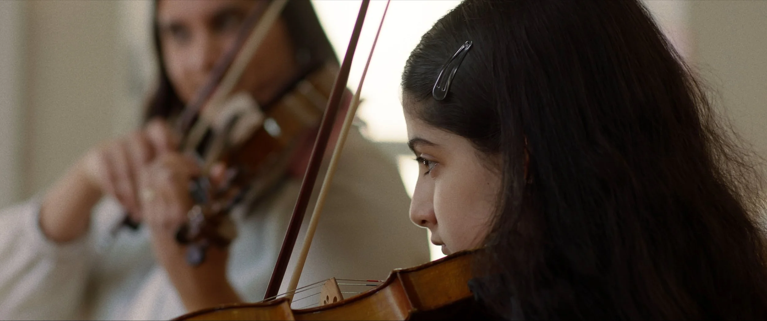 A close up of Zara playing the violin