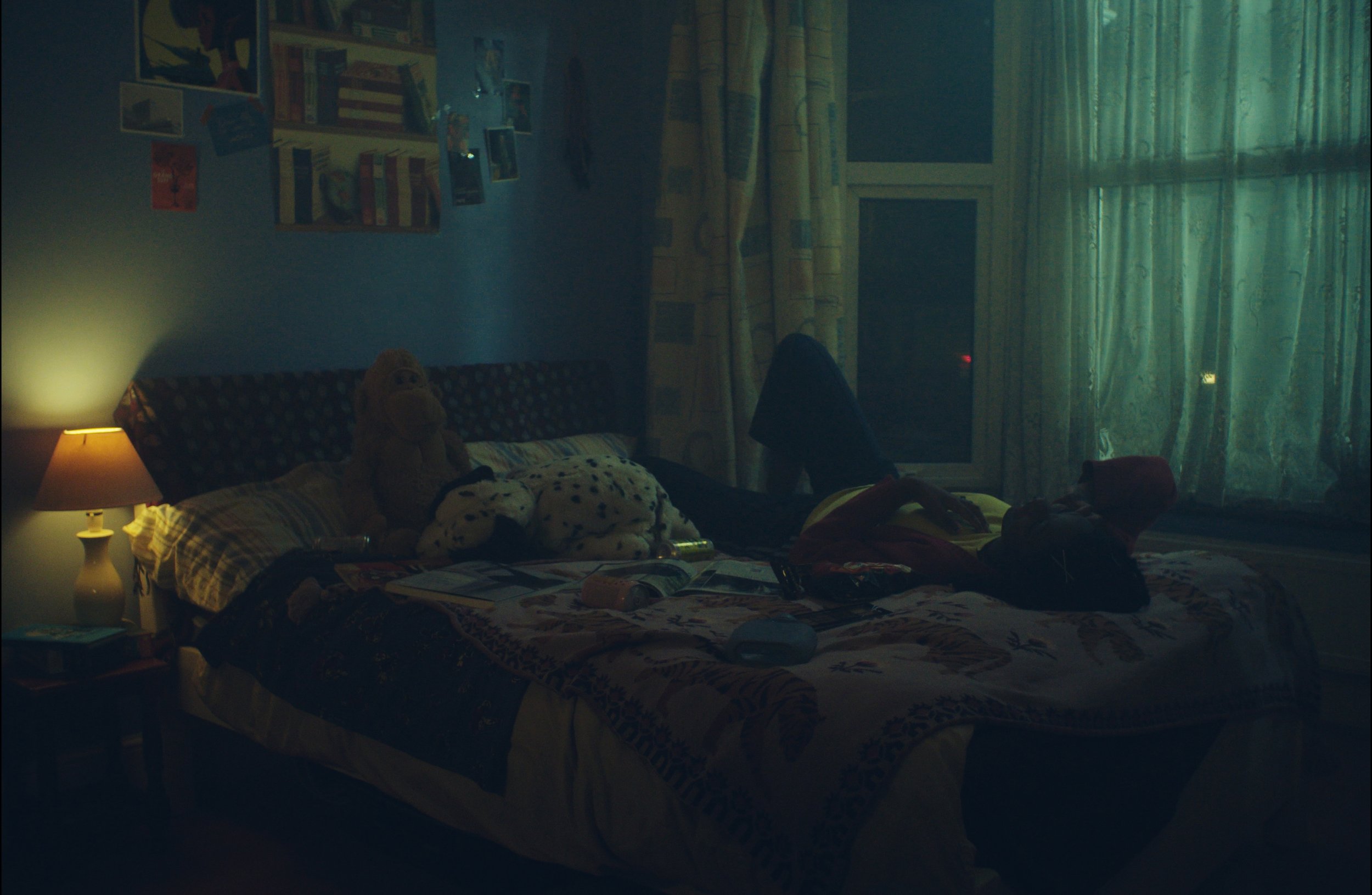 A woman lies on her bed as she talks on the phone