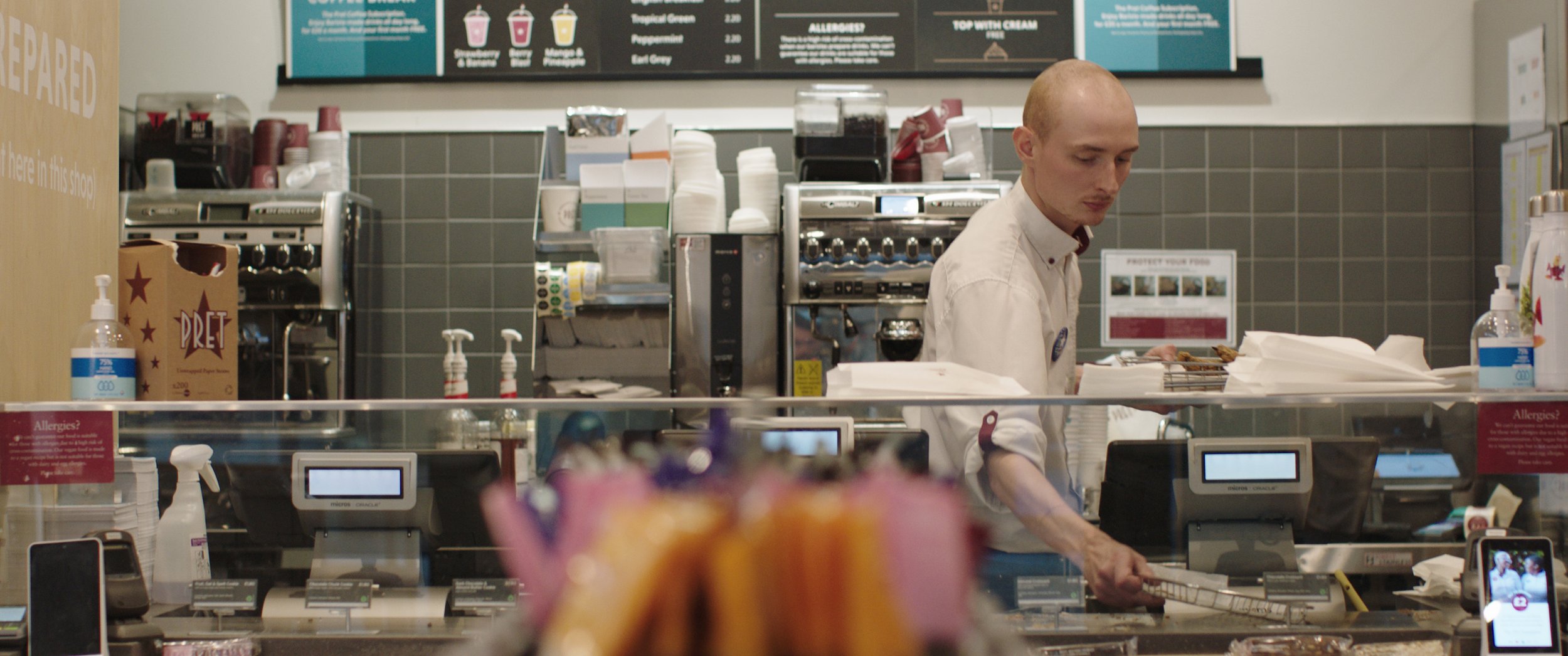 A Pret worker cleans the coffee station