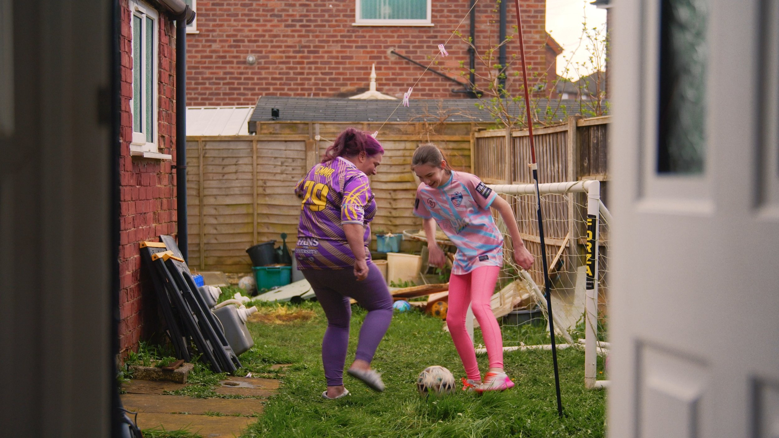 Emily and Emma play football in the garden