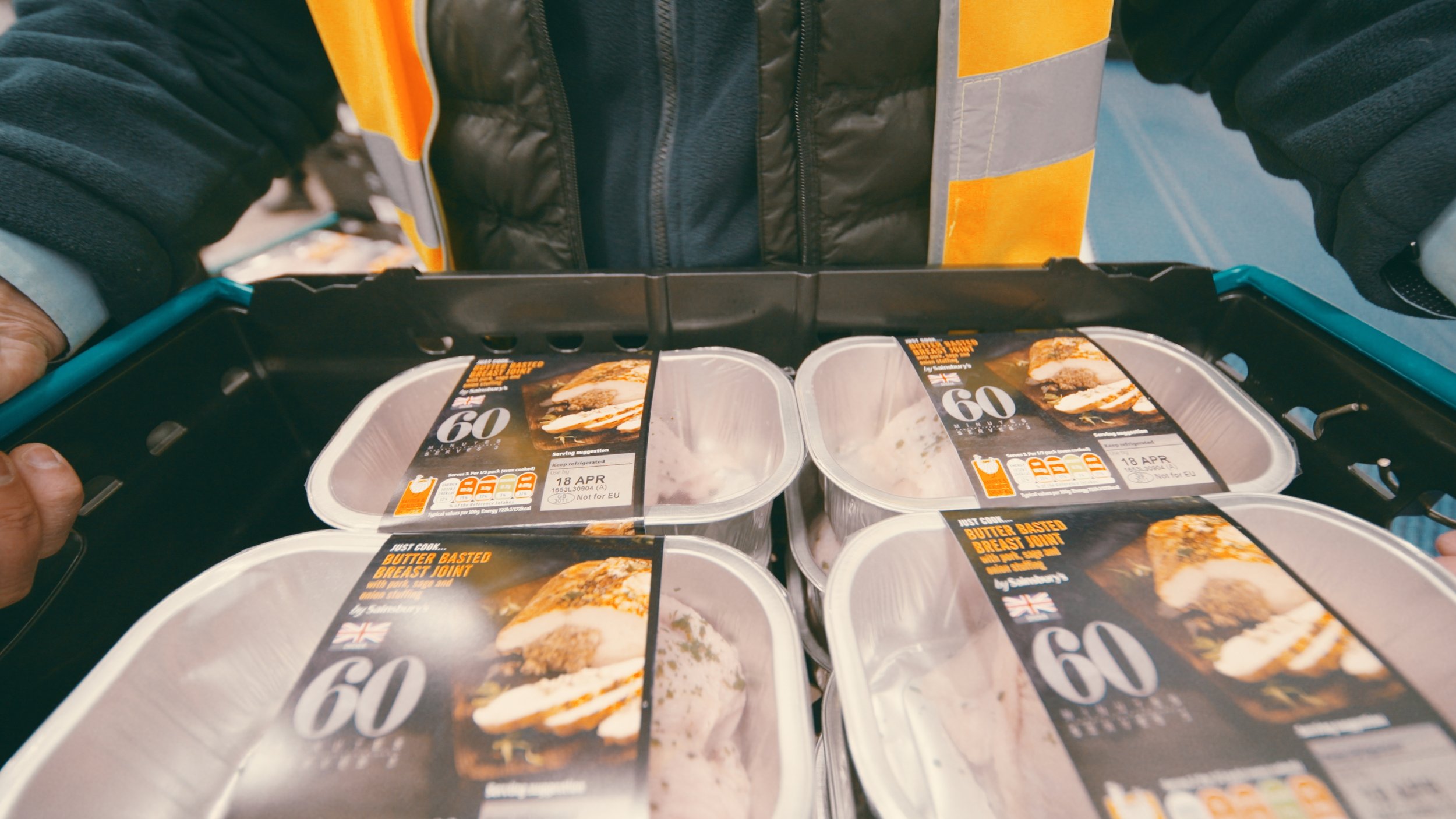 A Sainsburys worker carries a crate of packed chicken
