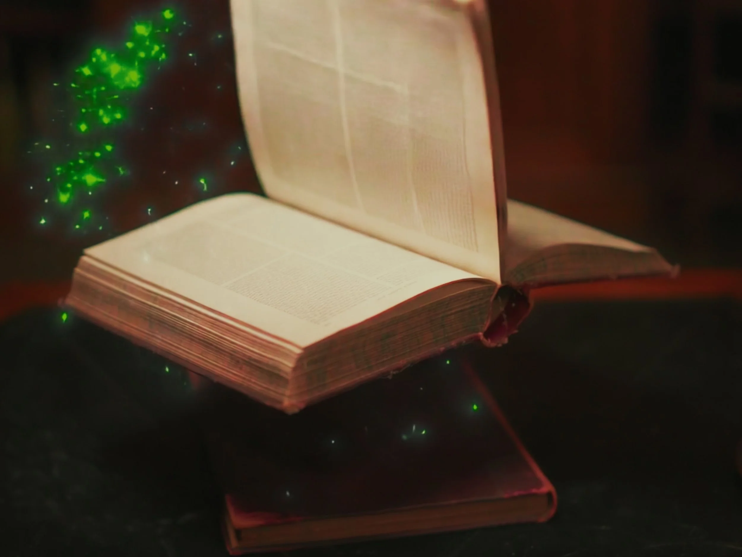 A splash of green magic surrounds a book as the page turns