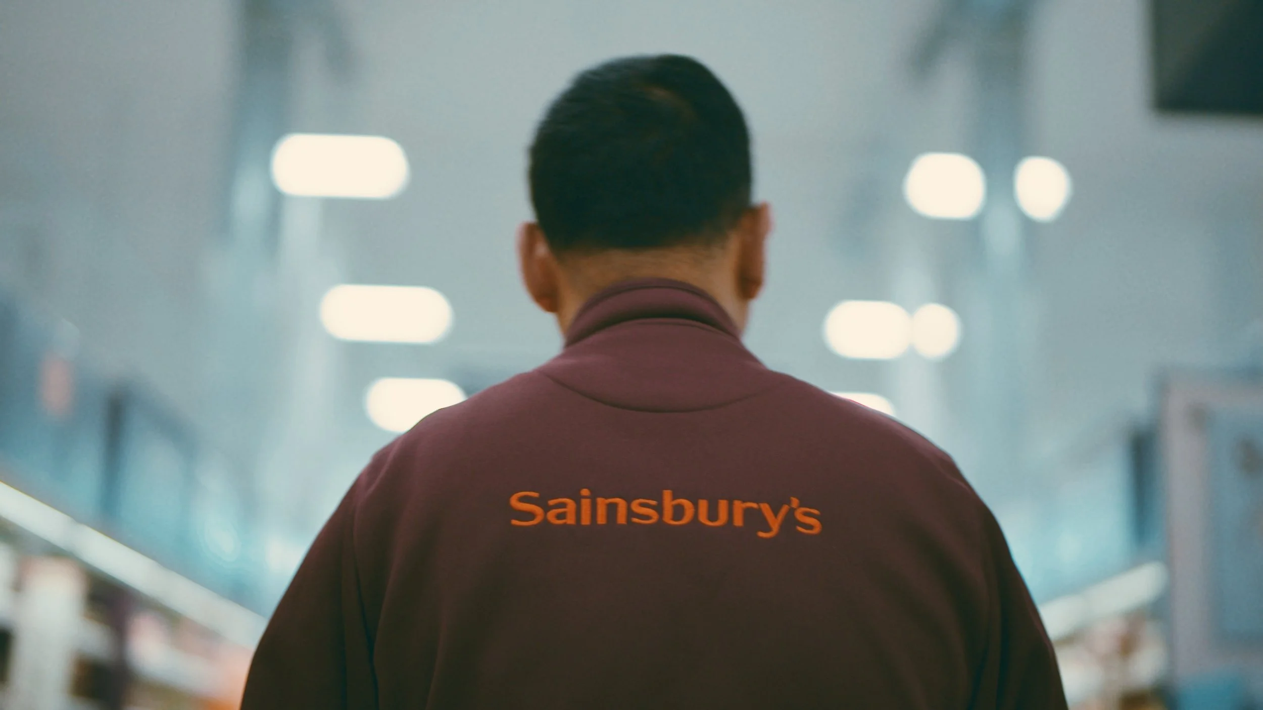 A Sainsburys worker walks through the store