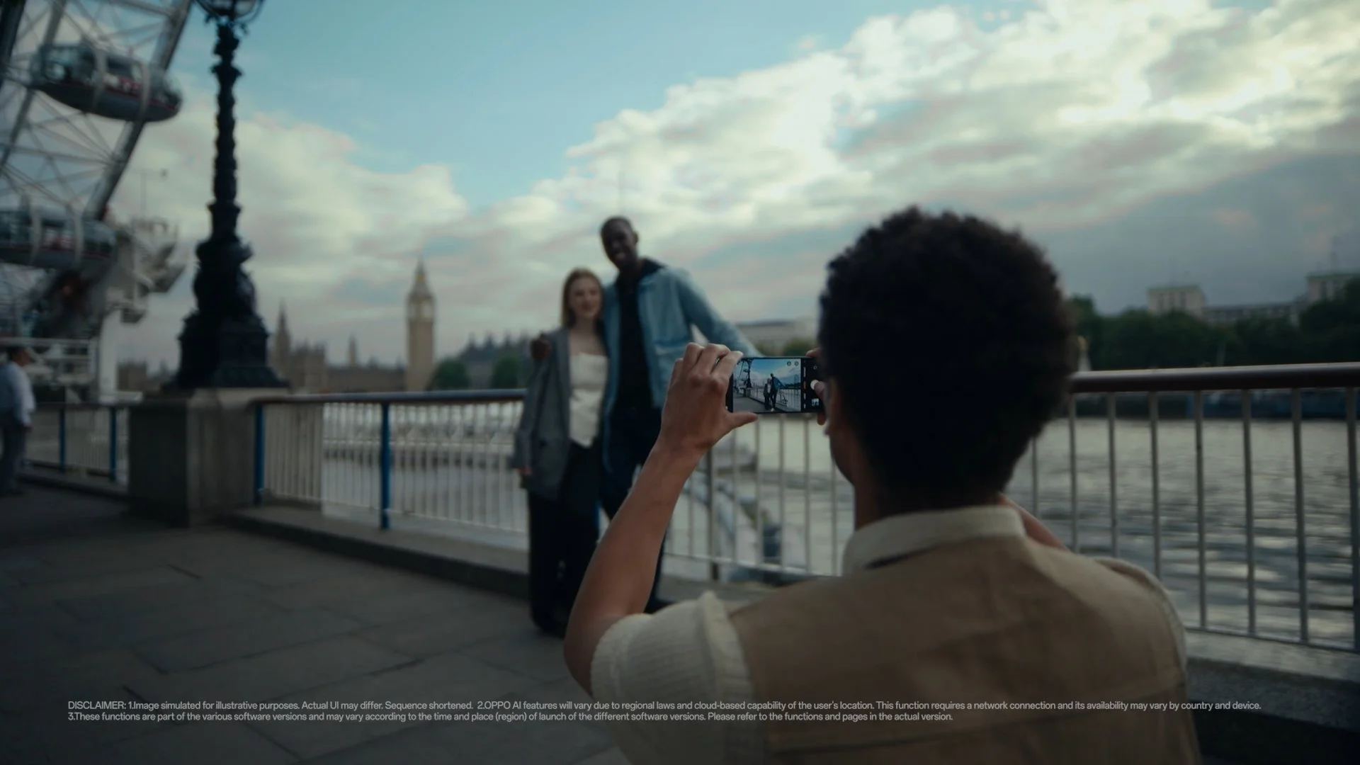 A man takes a picture of a couple next to the London Eye on his  OPPO Omega phone