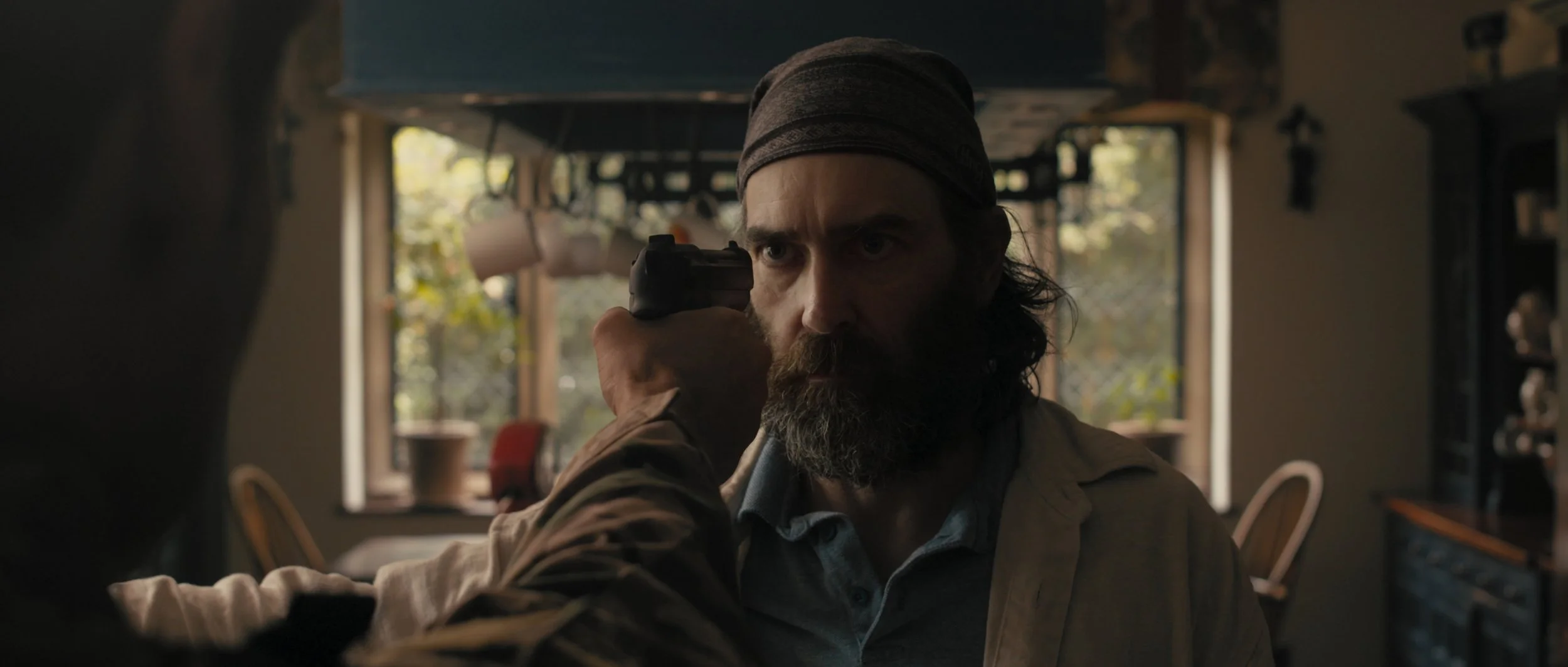 A gun is pointed at a man's face