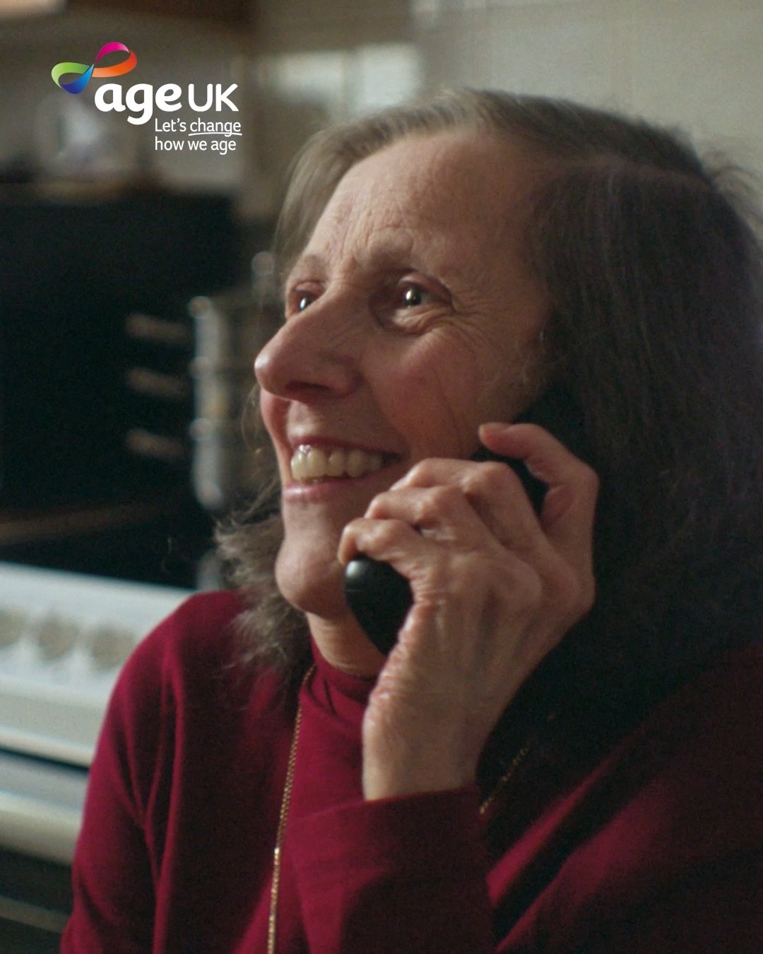 Sandra laughs while on the telephone, Age UK