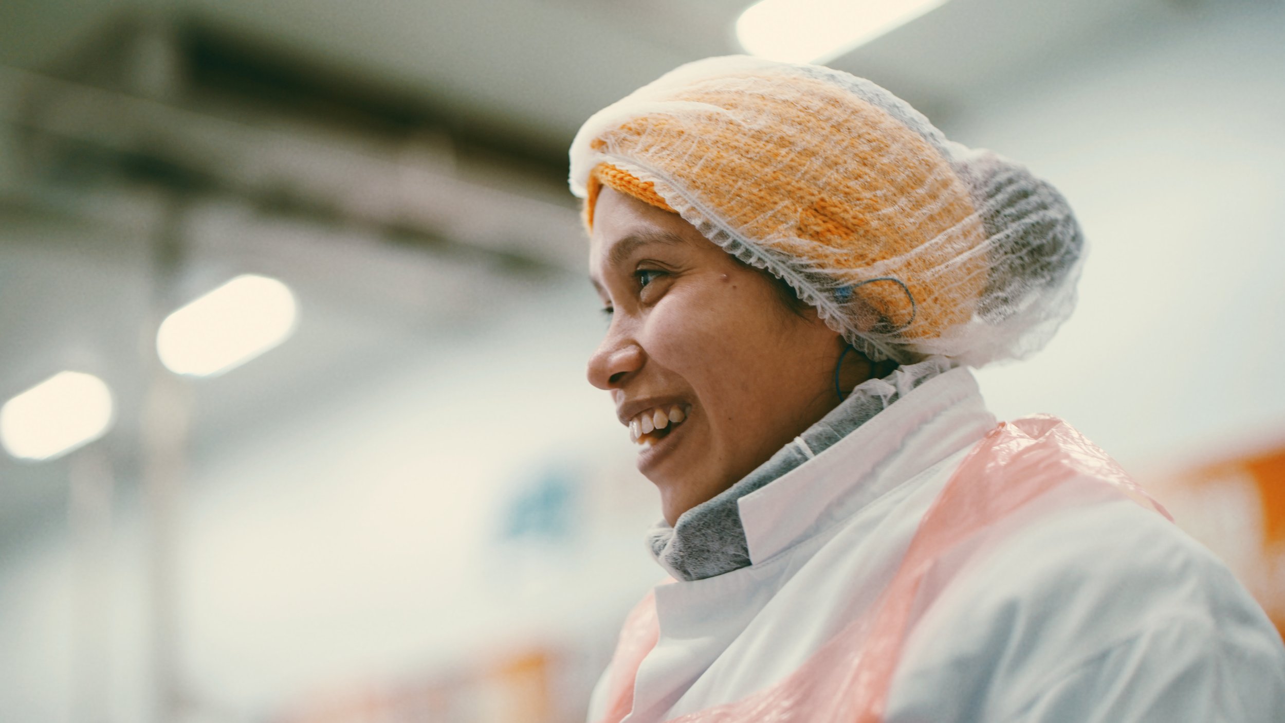 A Sainsburys worker smiles as she works