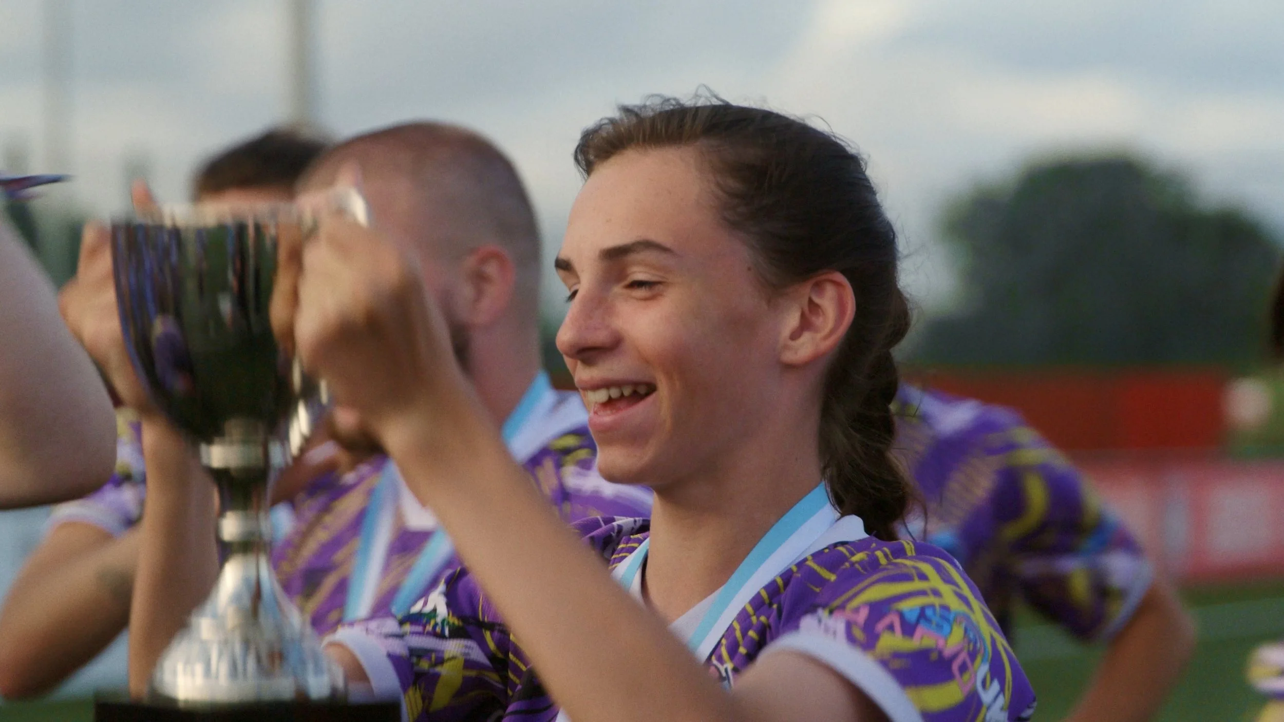 Emily lifts a trophy after a team win