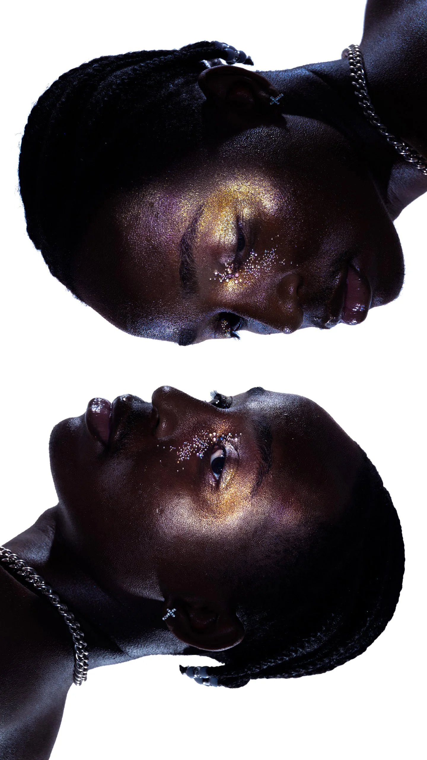 A person with dark skin and short hair with glitter makeup, shown in a mirror reflection against a white background.