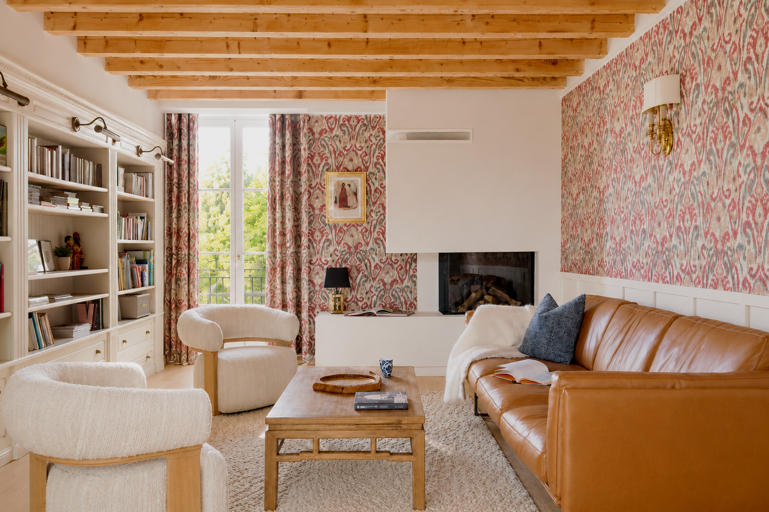 Intérieur de l’Orangerie Lyon avec mur en tissu tendu rouge et beige, ambiance chaleureuse et texturée, chaise longue LC4 iconique recouverte de peau de vache, fauteuil de designer, bibliothèque et éléments décoratifs, grande fenêtre avec rideaux lai