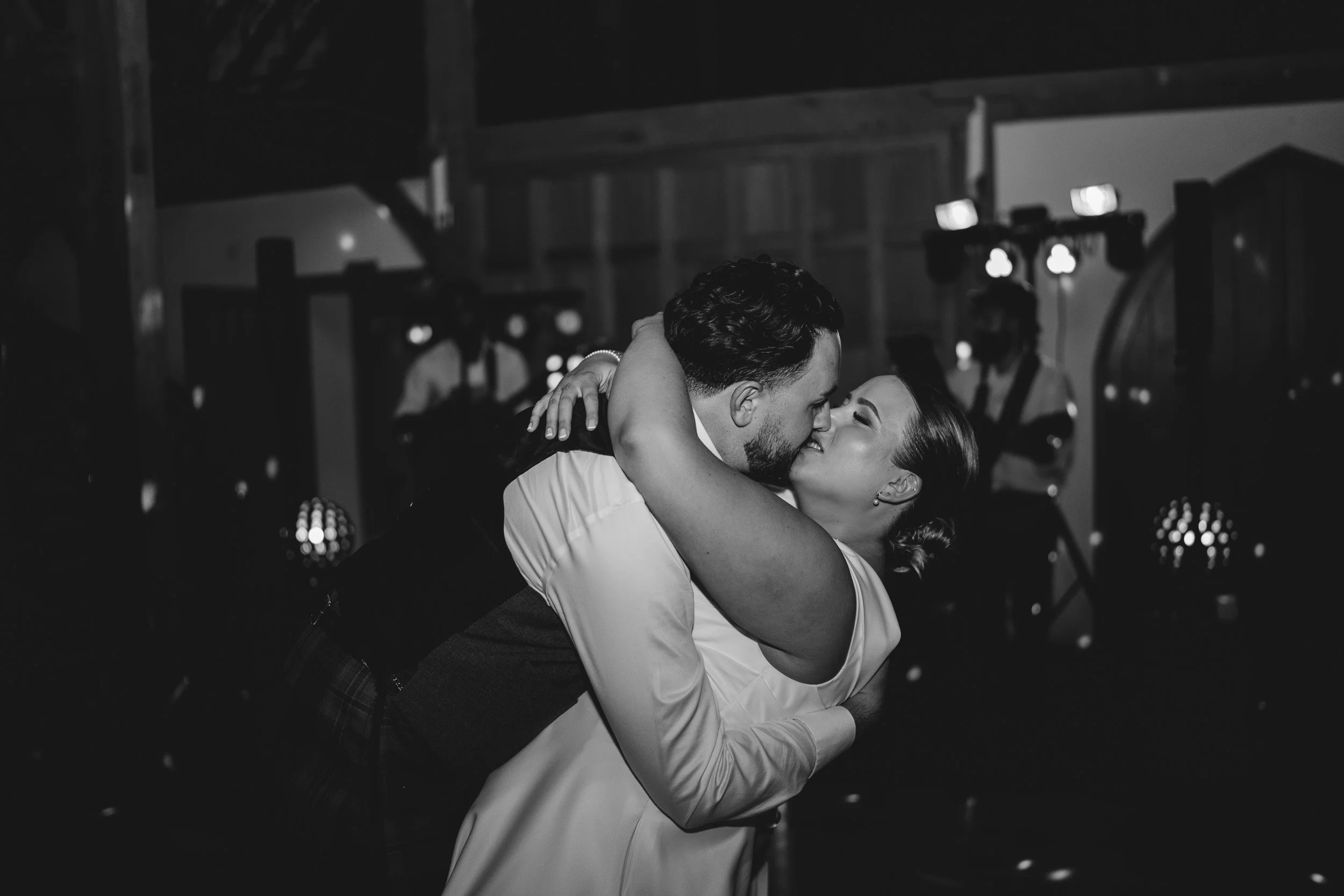 Bride and groom kissing during their first dance at Rivervale Barn wedding venue in Hampshire