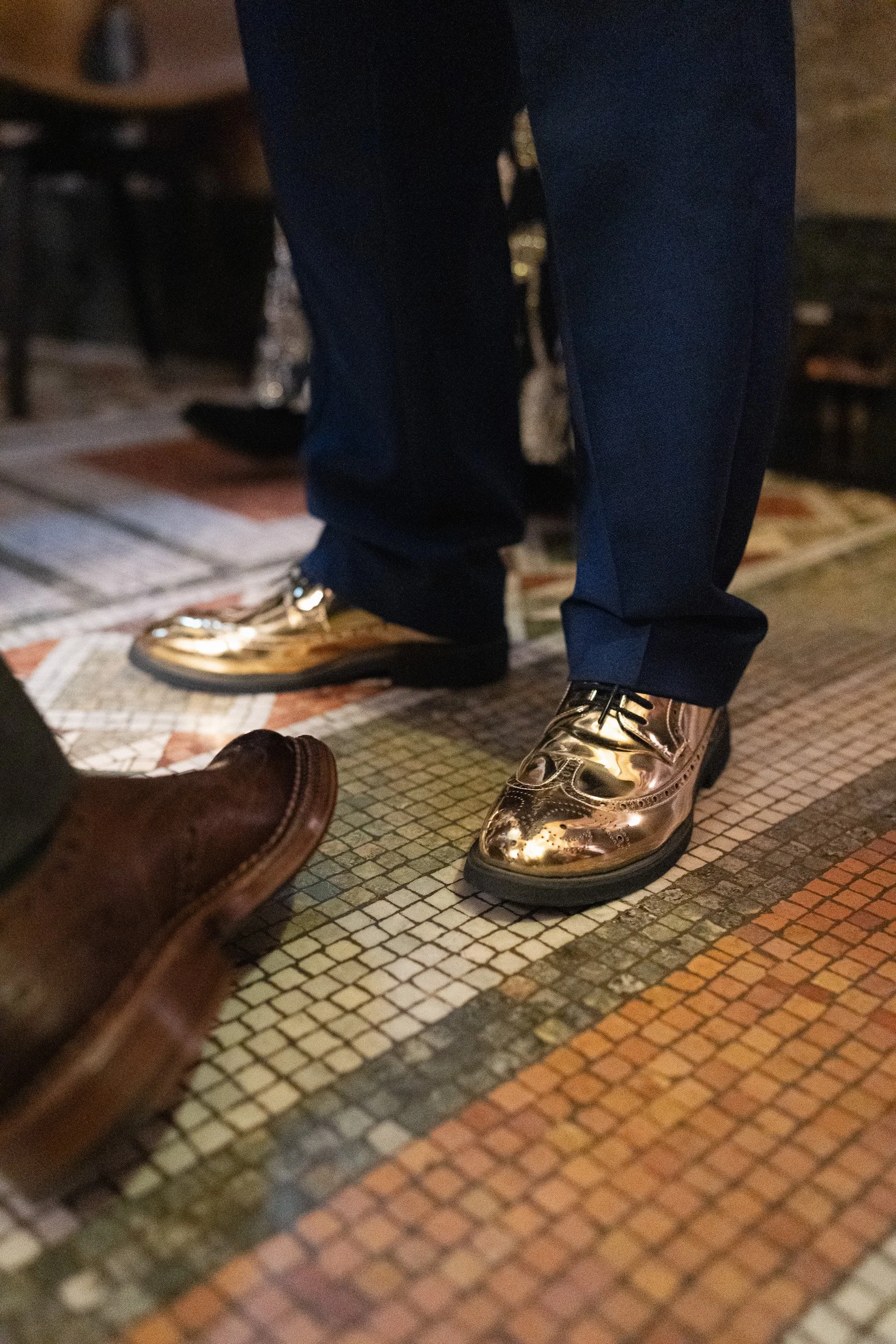 Guest wearing gold shoes standing on the floor of Fitzrovia Chapel in London
