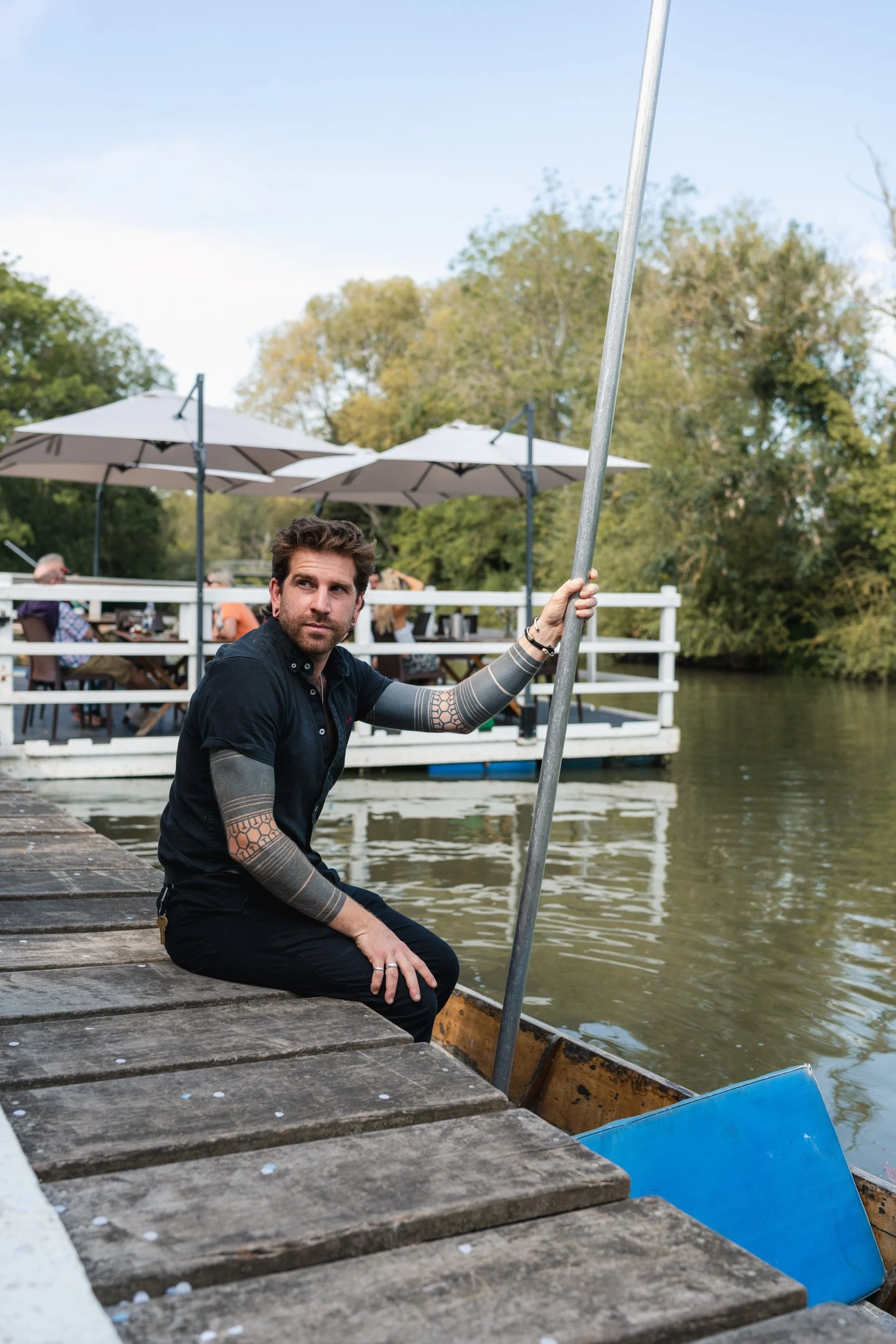 Punt boat guide waiting to help the bride and groom board a punt at Cherwell Boathouse in Oxford 