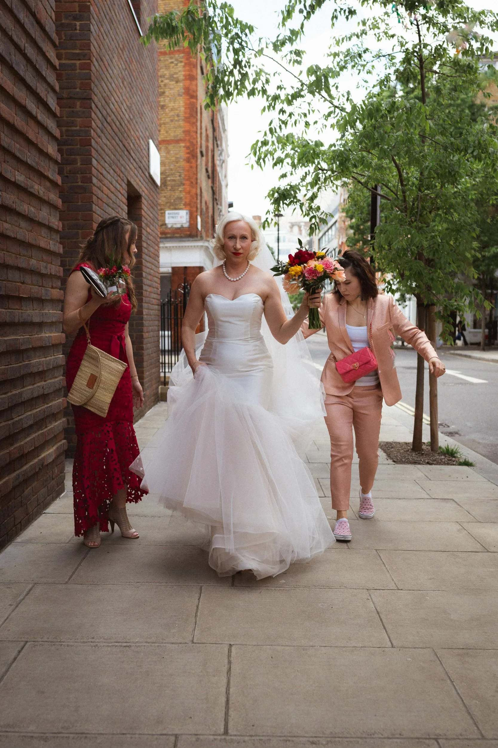 Bride and her brides maid late and rushing from The Union Club in Soho, London to Fitzrovia Chapel 