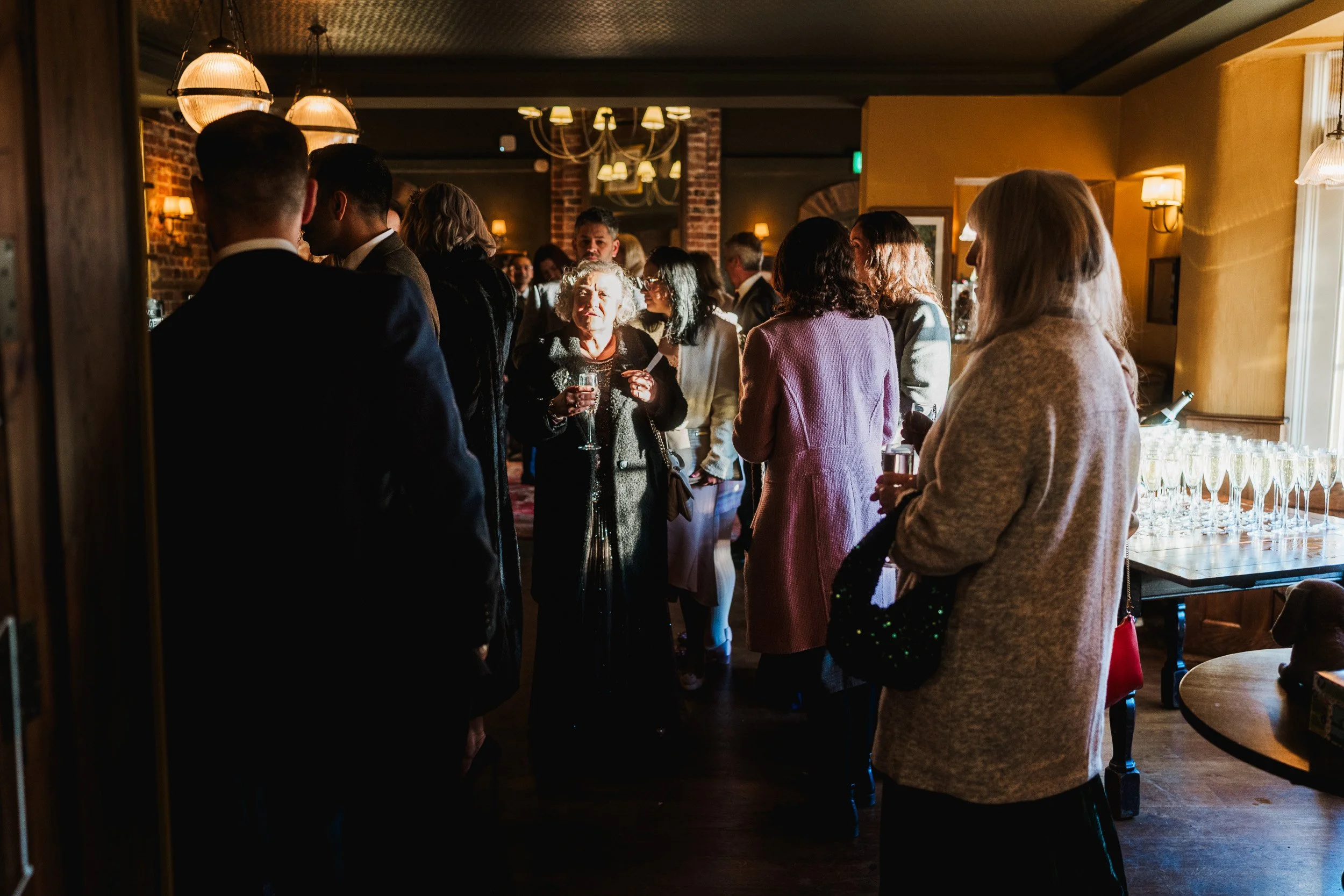 Wedding guests gather for drinks during the reception at The Bedford Arms in Chenies, Buckinghamshire