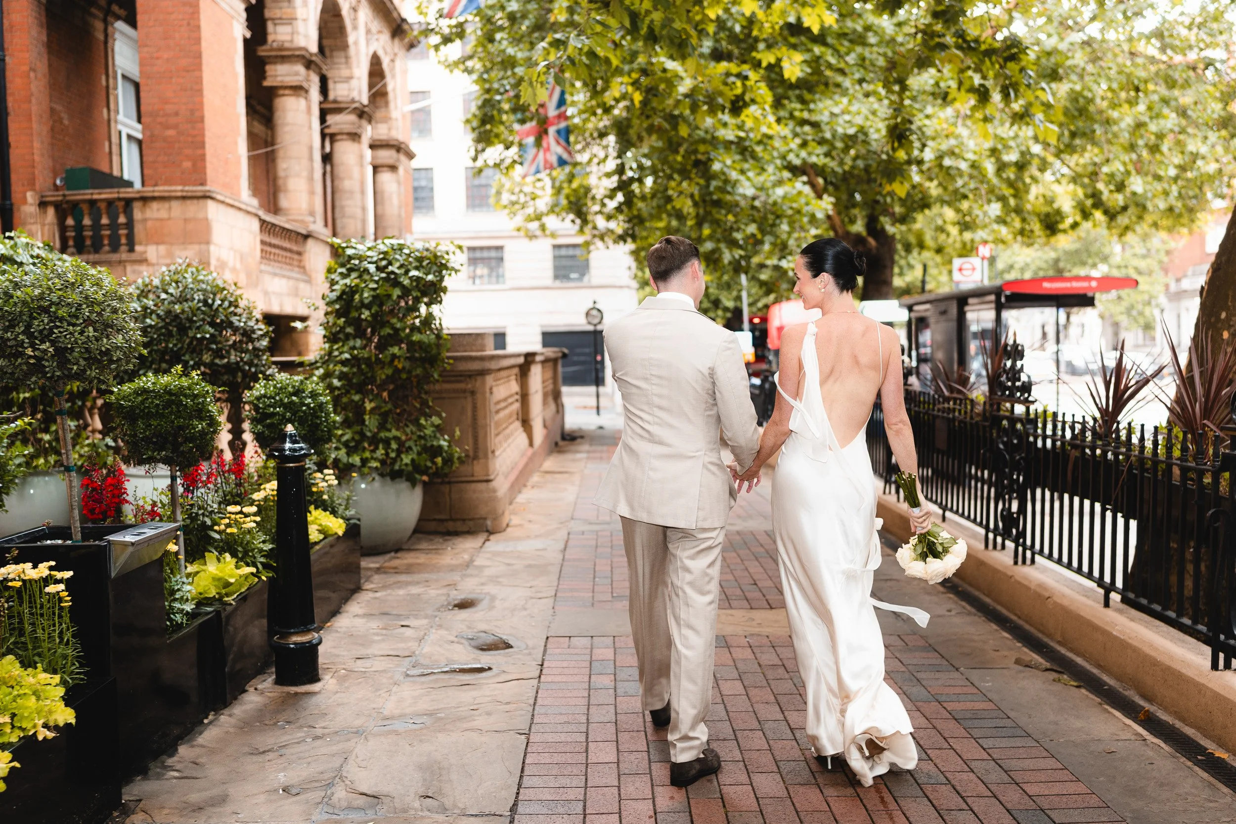 Bride and groom walking outside past The Landmark Hotel hand in hand to head to their wedding ceremony at Marylebone Registry Office in London