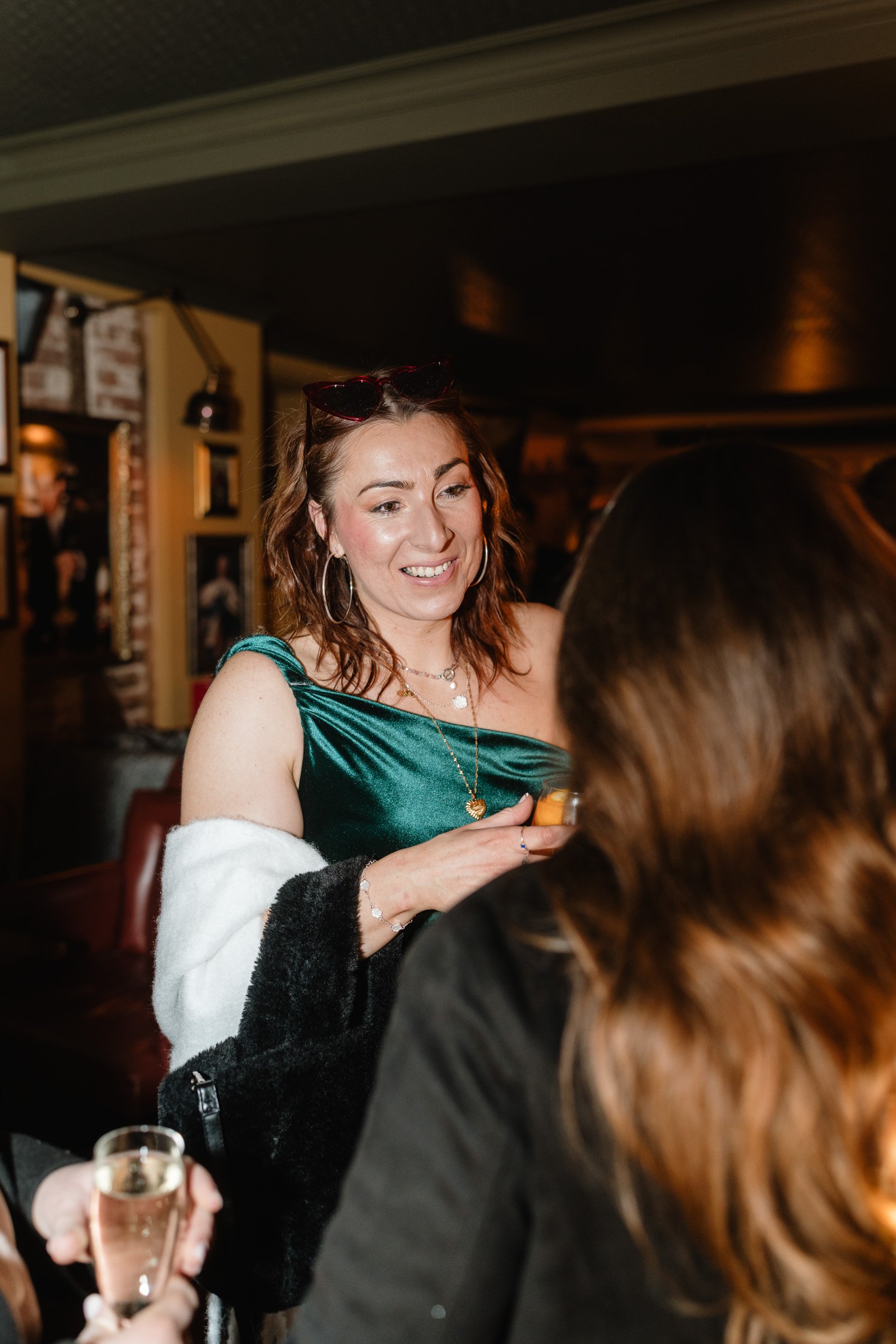 Wedding guests smiling and chatting during the reception at The Bedford Arms in Chenies, Buckinghamshire