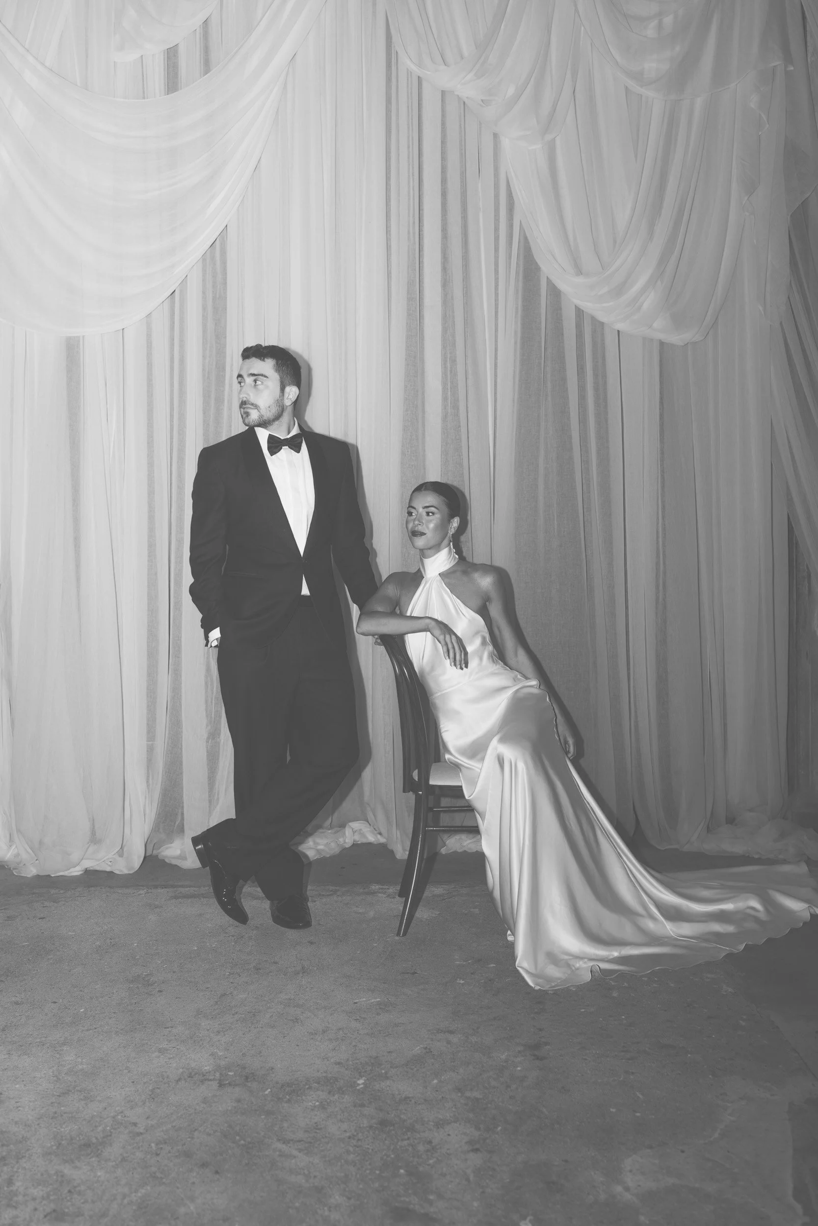 The bride and groom sitting together in their   reception room with flowing drapery inside The Bell Tower at The Elvetham Hotel in Hampshire