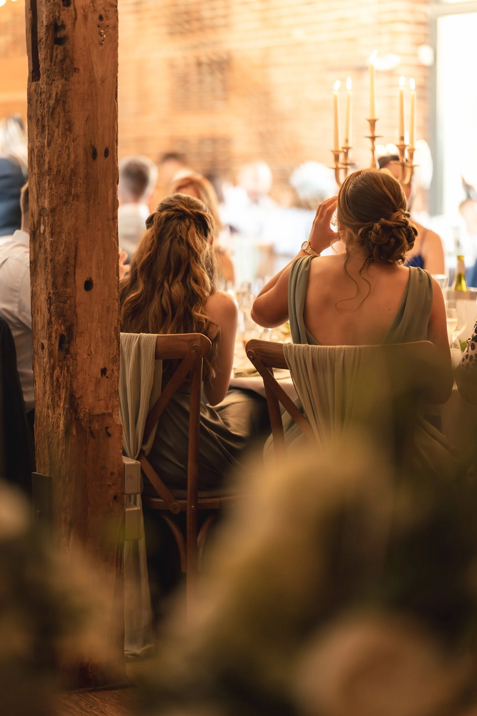 Bridesmaids raising a cheer in a candle lit room at the wedding  reception Wasing Park in Berkshire 