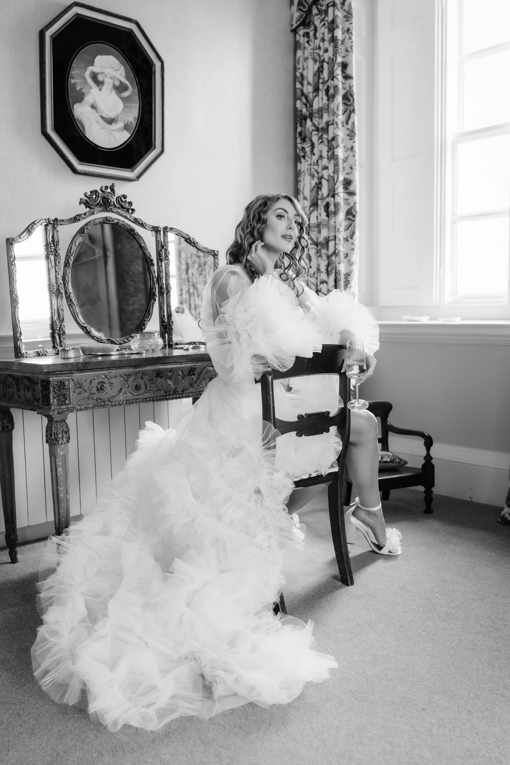 Bride sitting in bridal lingerie and wedding gown in a suit at Kirtlington Park in Oxfordshire