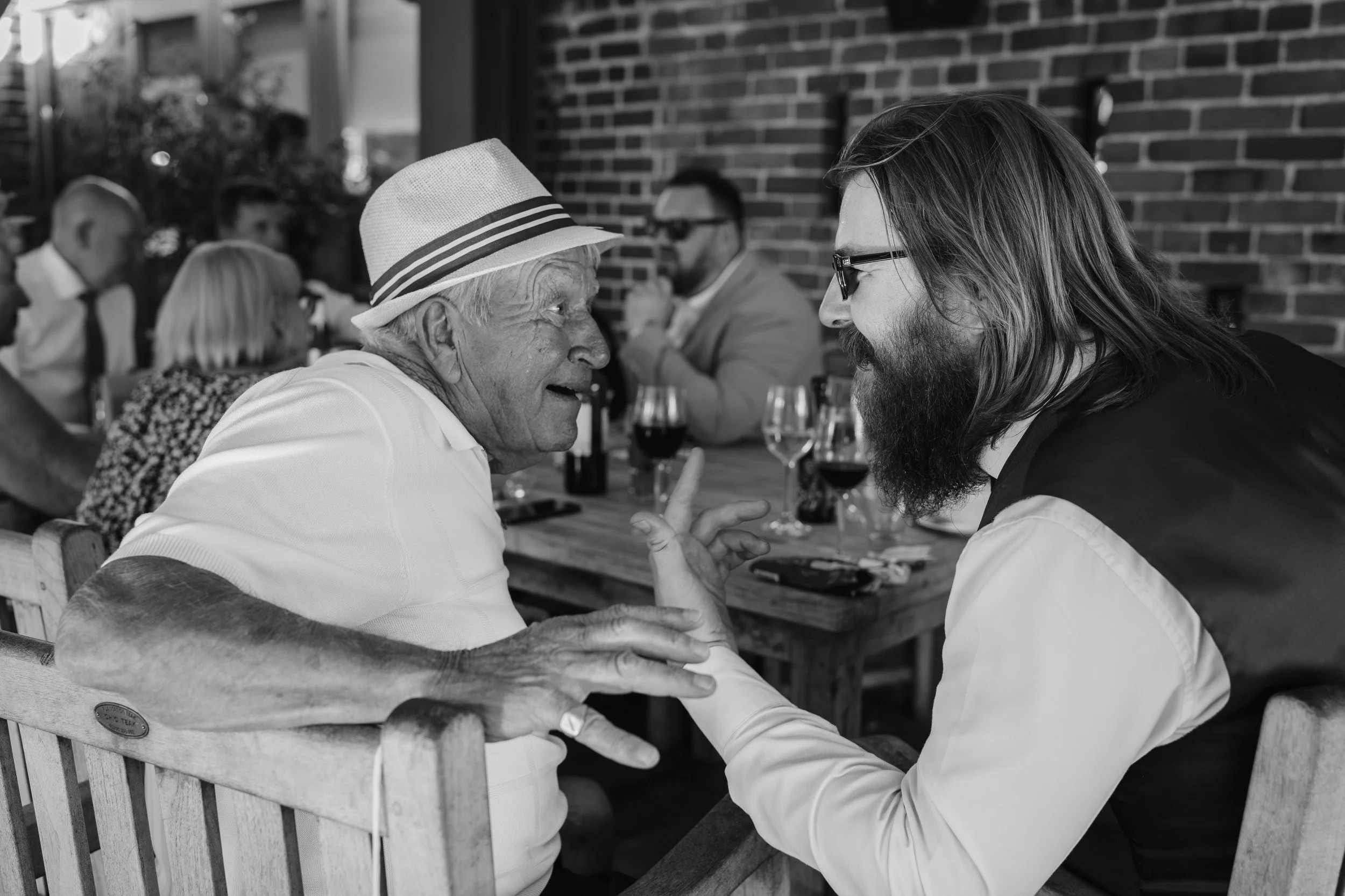 Wedding guests in cheerful conversation at a wedding reception on the patio of Wasing Park, Berkshire