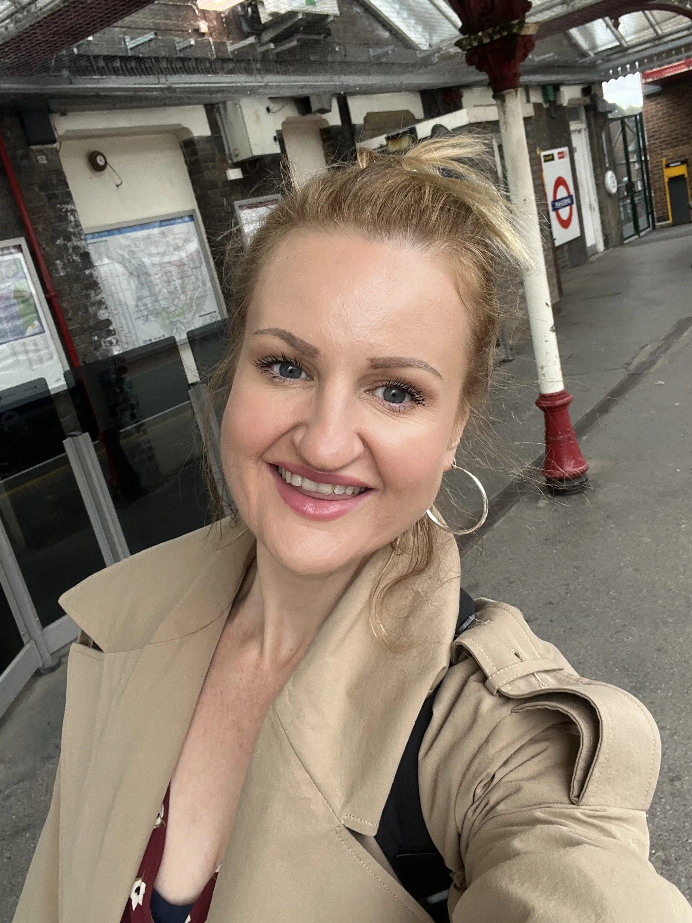 Wedding photographer smiling at the train  station on the way to photograph a wedding