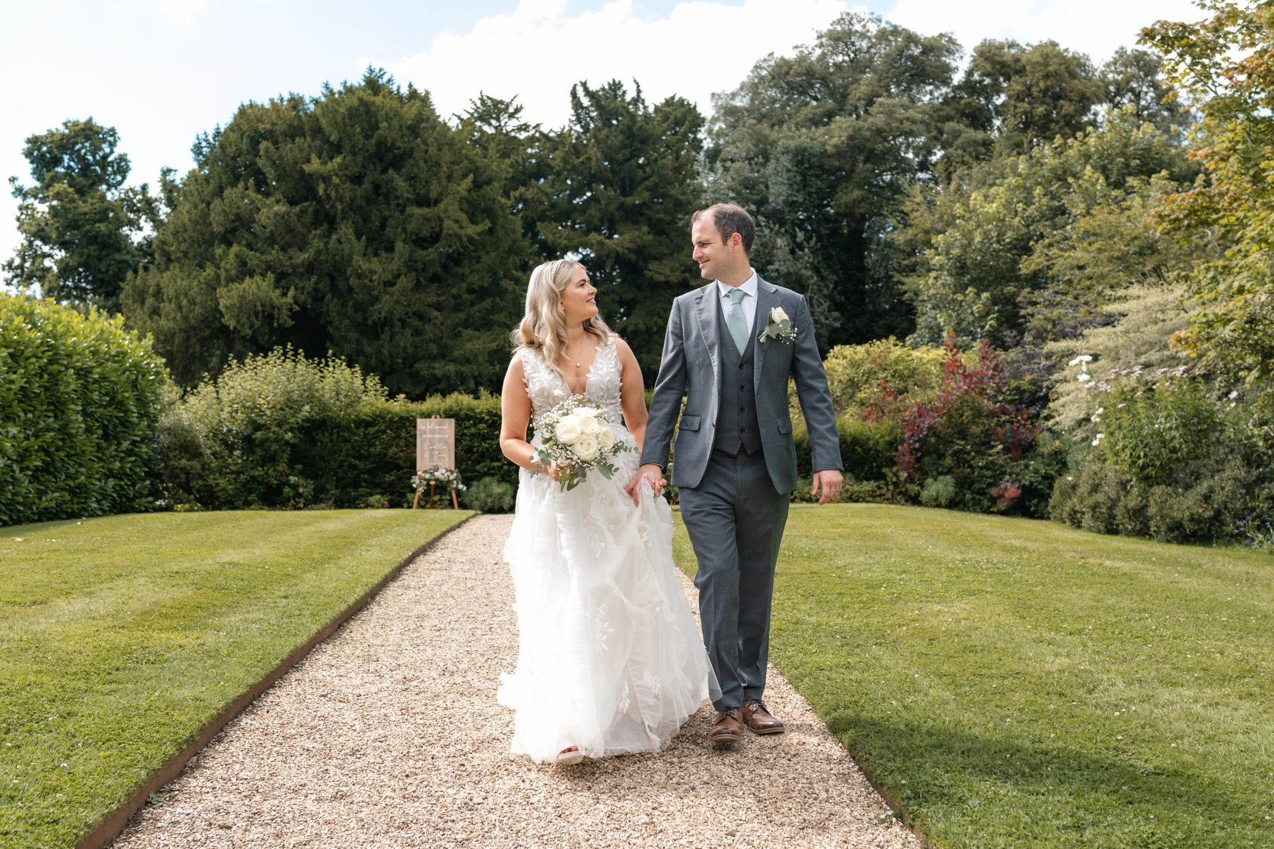 Bride and groom taking a walk hand in hand through the gardens of Wasing Park in Berkshire after the wedding ceremony 