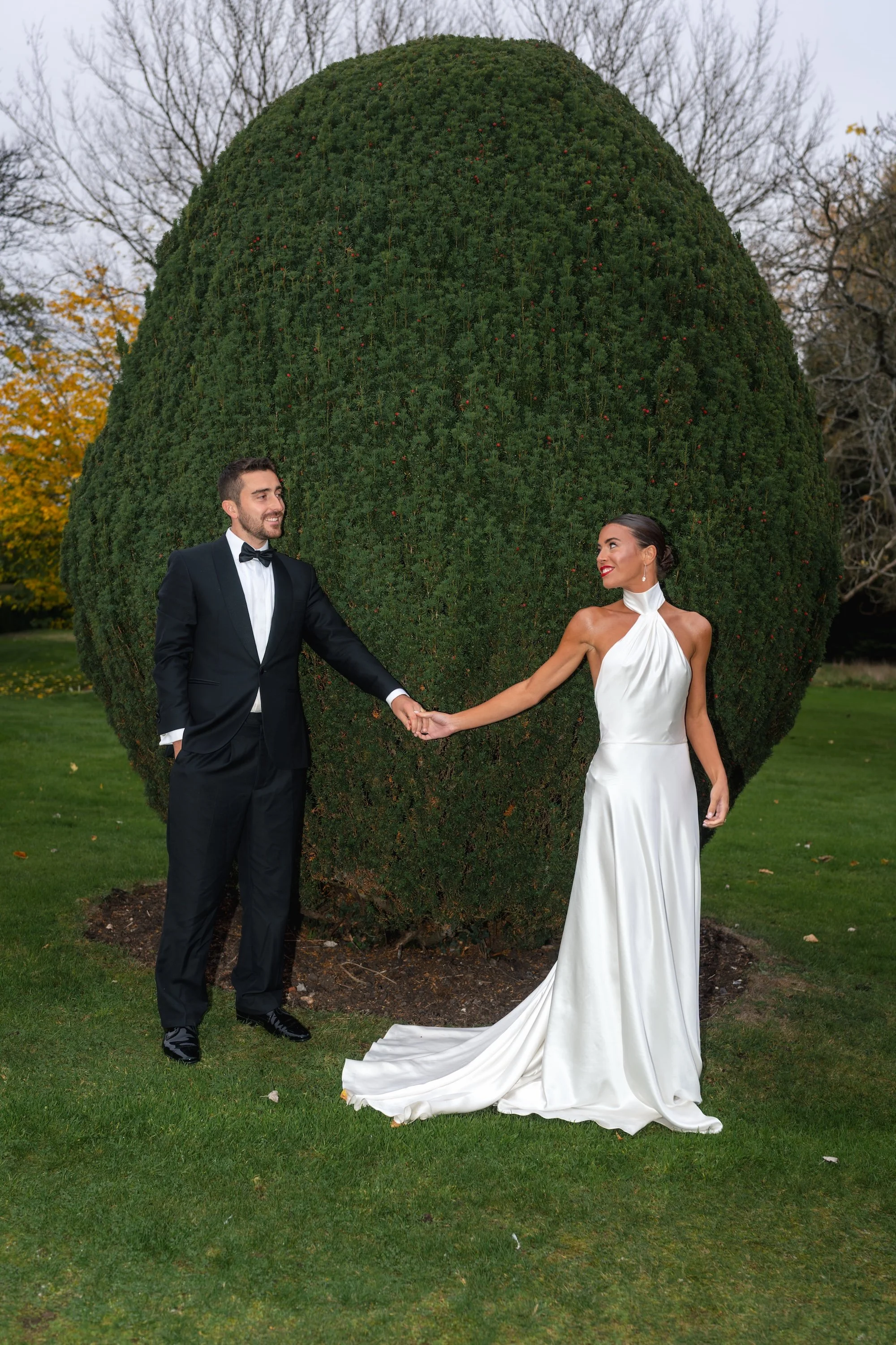 Bride and groom wedding portrait in the Elvetham gardens beside sculptural clipped greenery