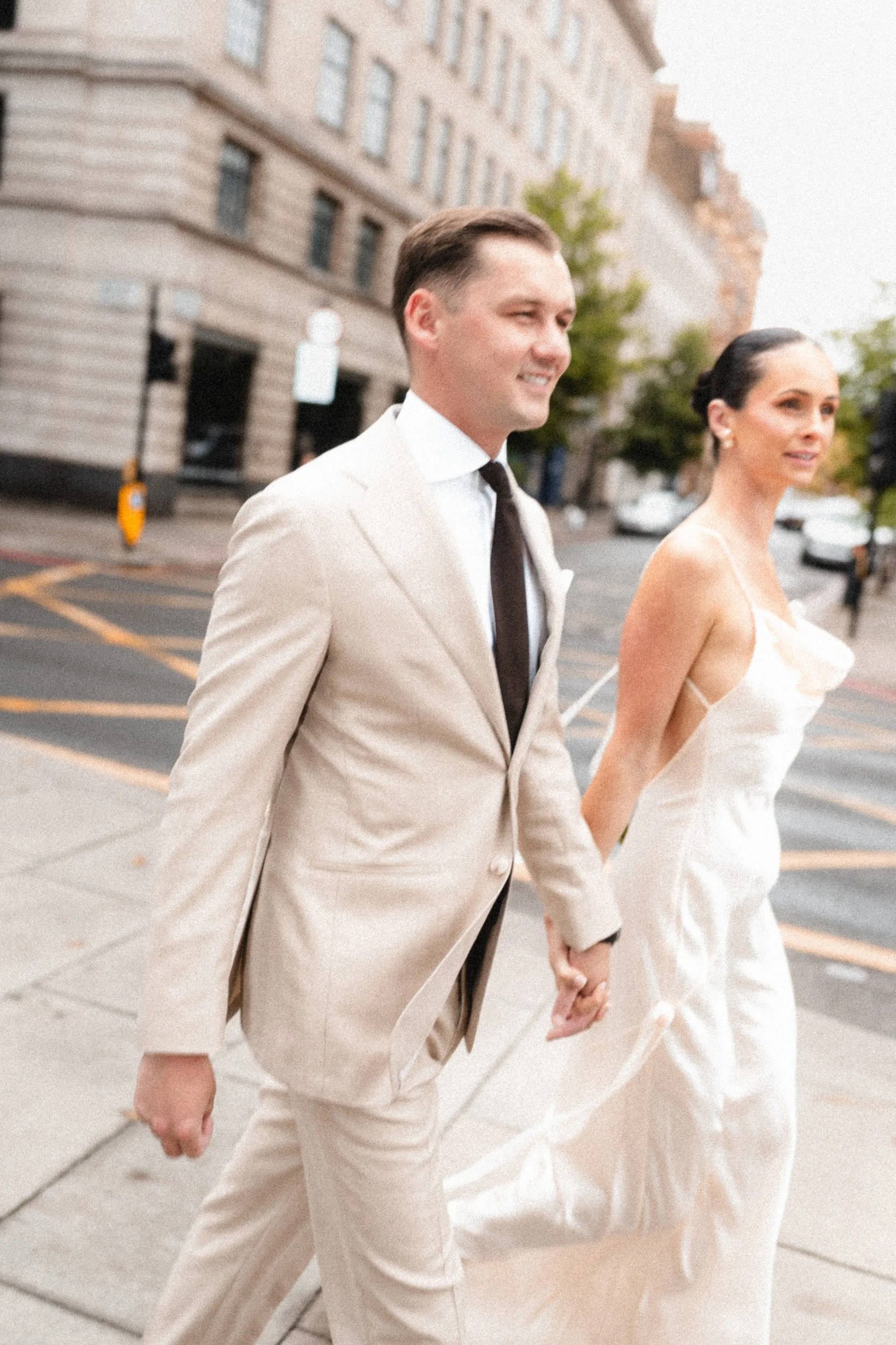 Close up of a bride and groom walking hand in hand in the london streets to Marylebone Town Hall Registry Office in London