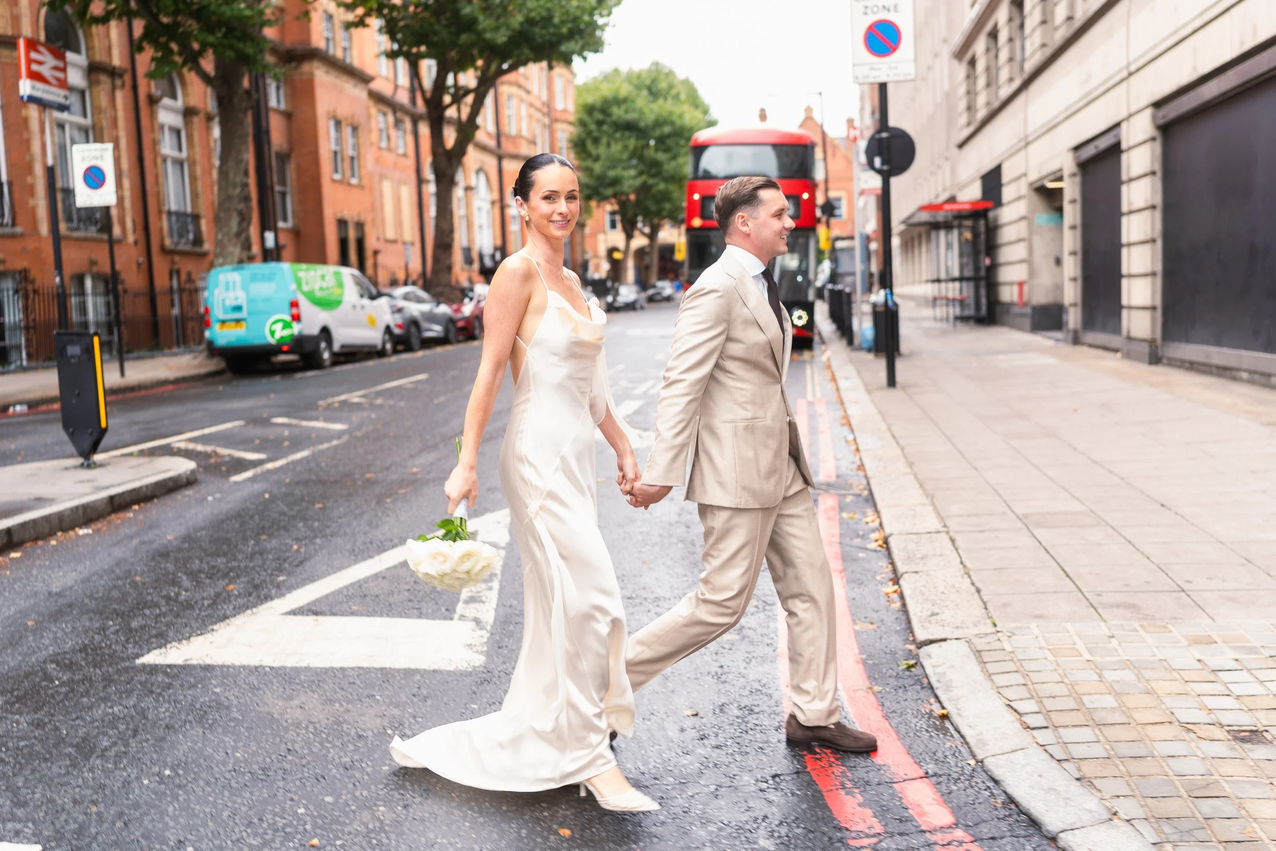 Bride and groom walking hand in hand from The Landmark Hotel to  Marylebone Town Hall Registry Office in London