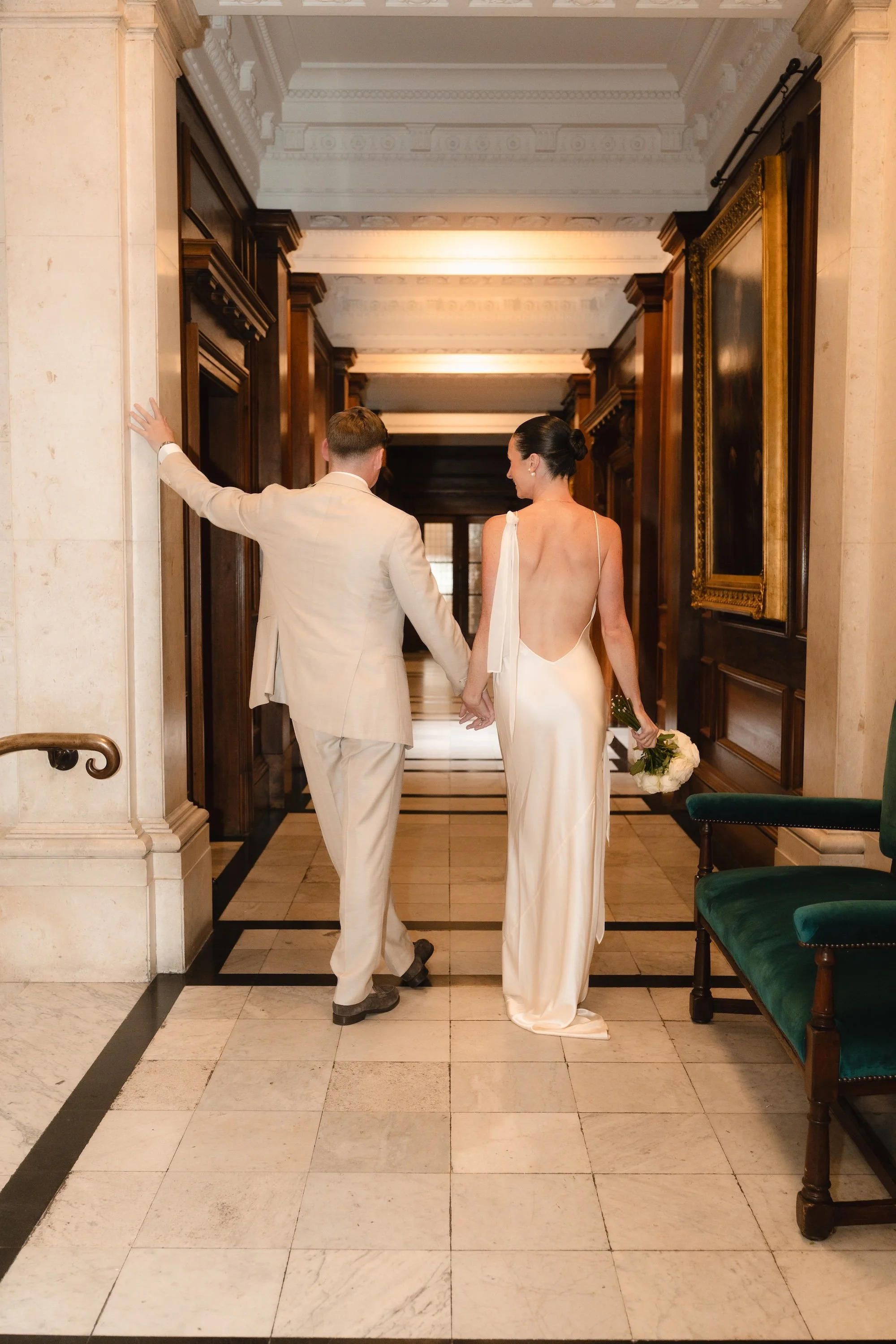 Bride and groom waiting in the hallways of Old Marylebone Town Hall to enter the Paddington Room for their intimate London civil wedding ceremony