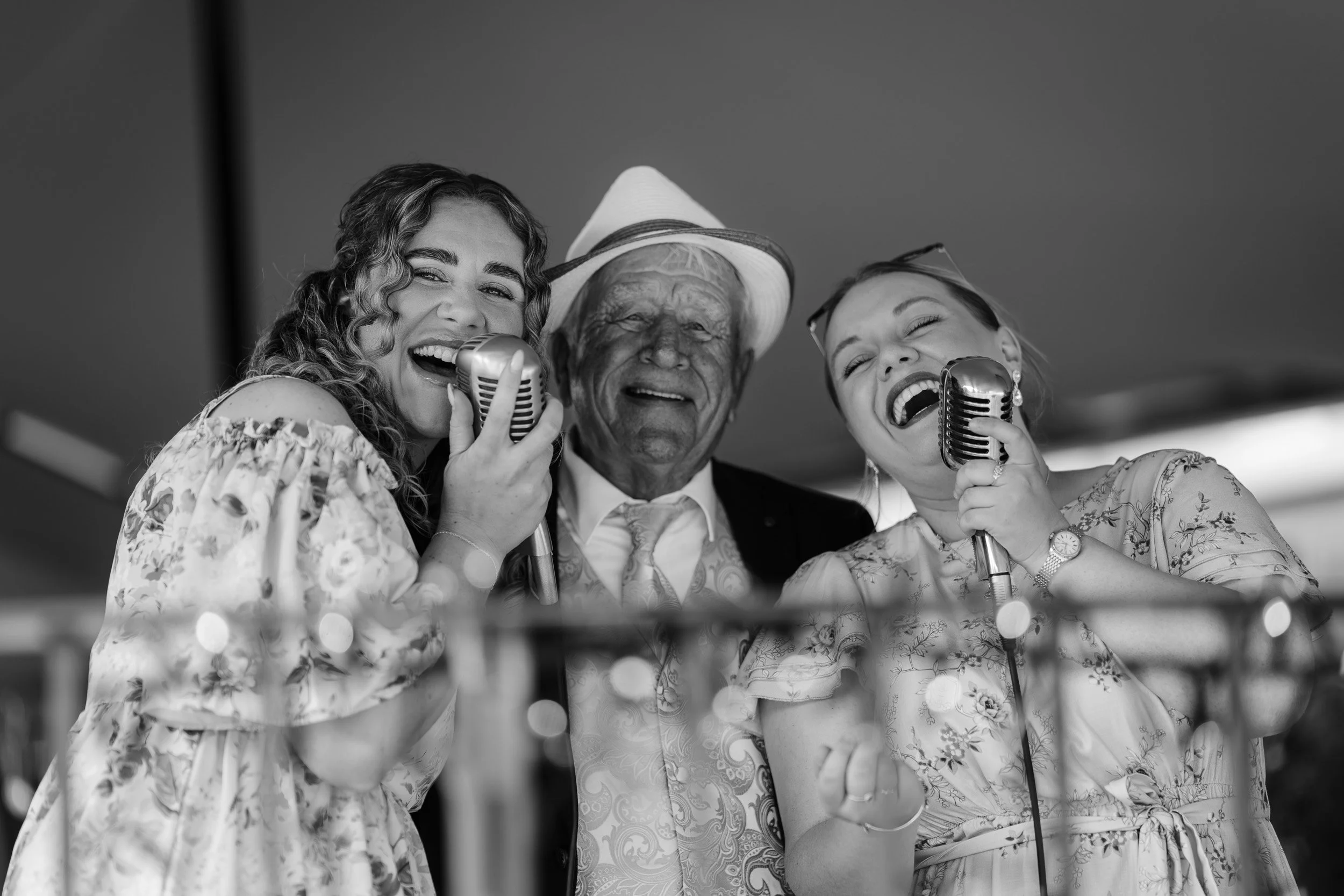 Grandfather of the bride with Harmony Wedding Duo singing with vintage microphones after the wedding ceremony at Wasing Park in Berkshire