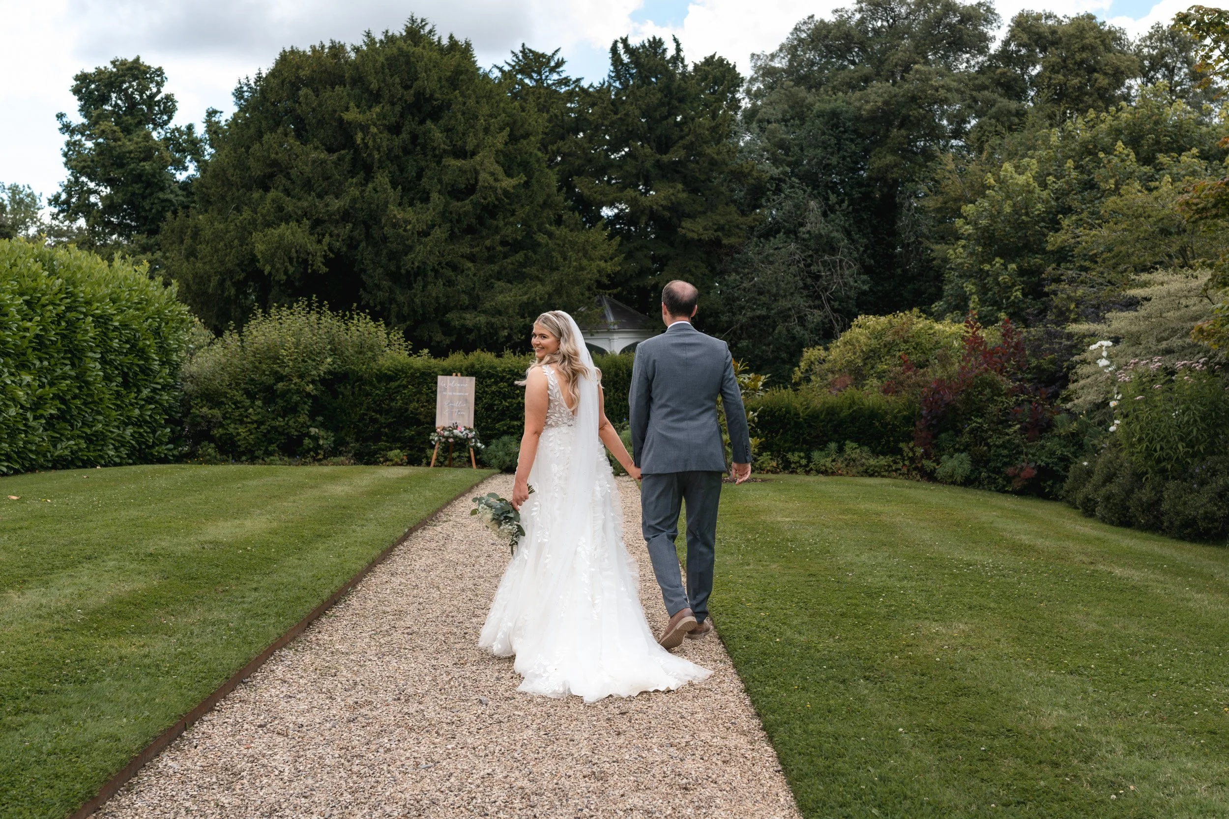 Bride and groom taking a walk through the gardens of Wasing Park in Berkshire after the wedding ceremony 