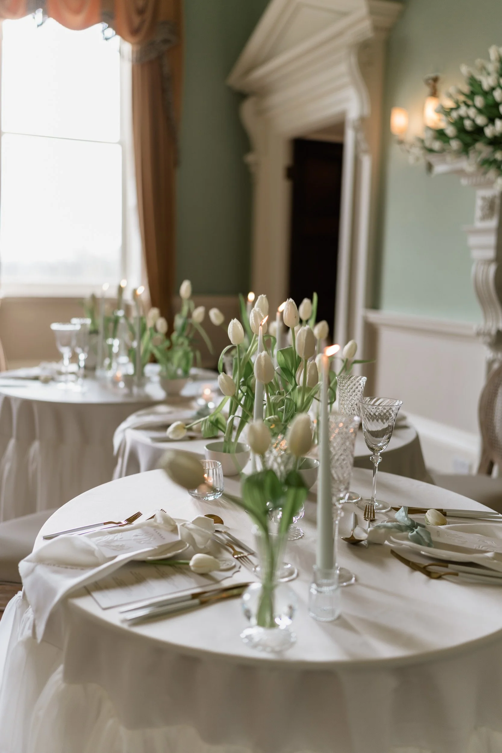 Tulip and candle-lined head table for the wedding reception at Kirtlington Park in Oxfordshire