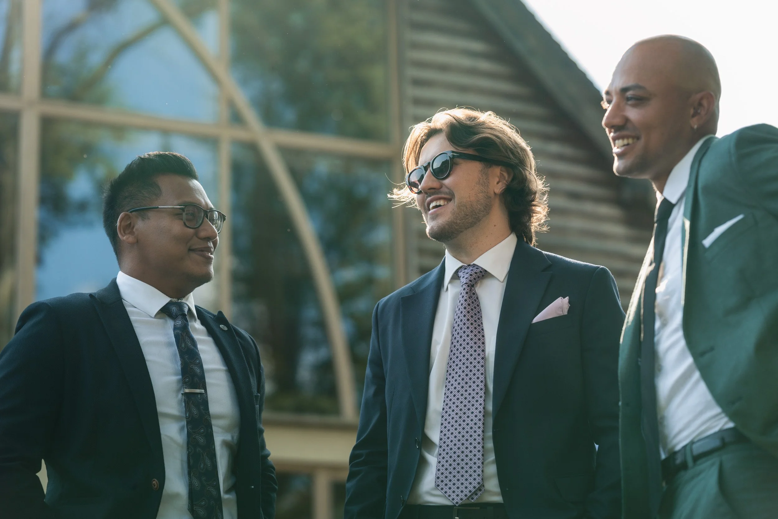 Groomsmen at Rivervale Barn in Hampshire chatting at the wedding reception